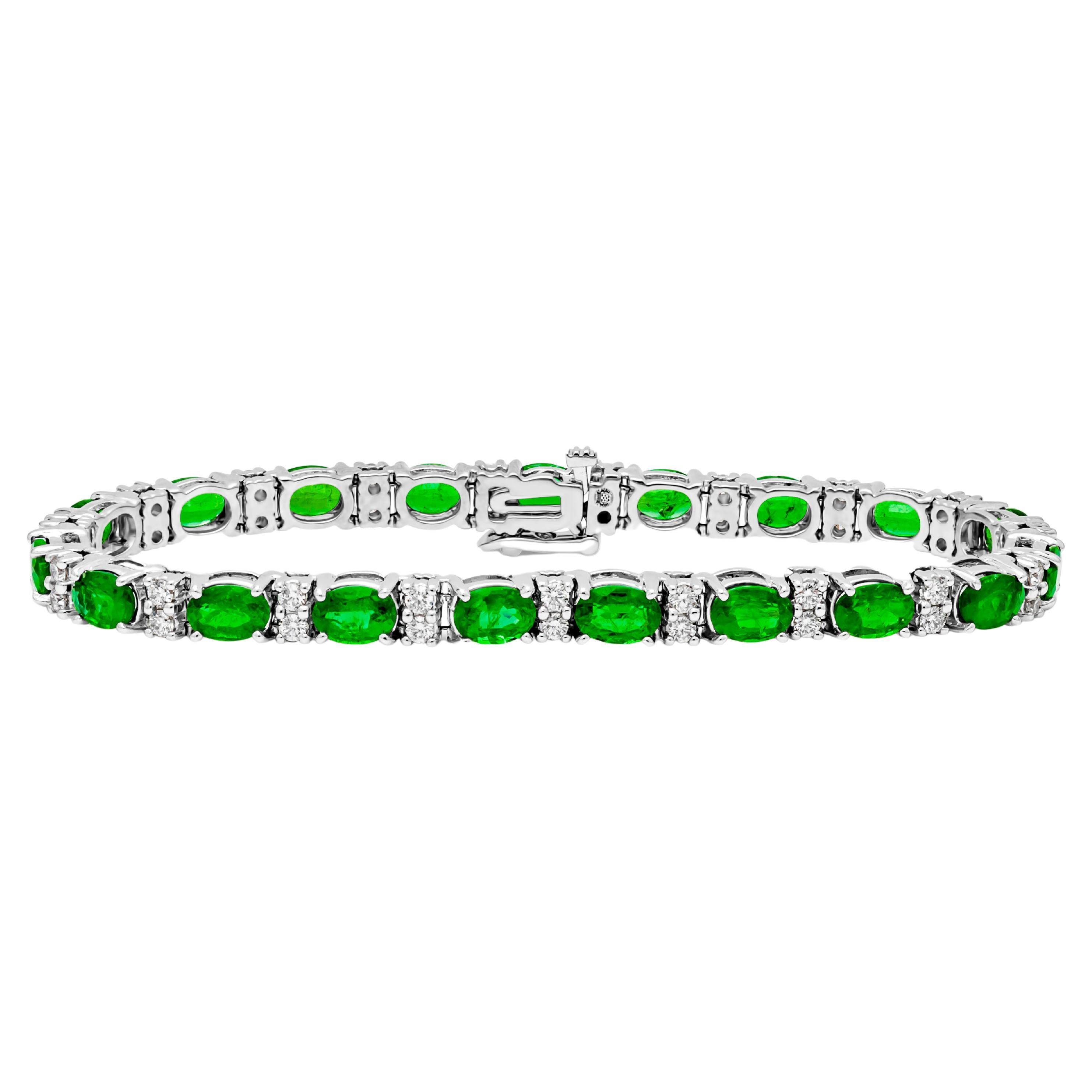 Un bracelet de tennis exquis et simple, mettant en valeur des émeraudes vertes de taille ovale d'un poids total de 8,48 carats, serties sur une monture panier classique à quatre griffes finement réalisée en or blanc 14K. Deux diamants ronds de