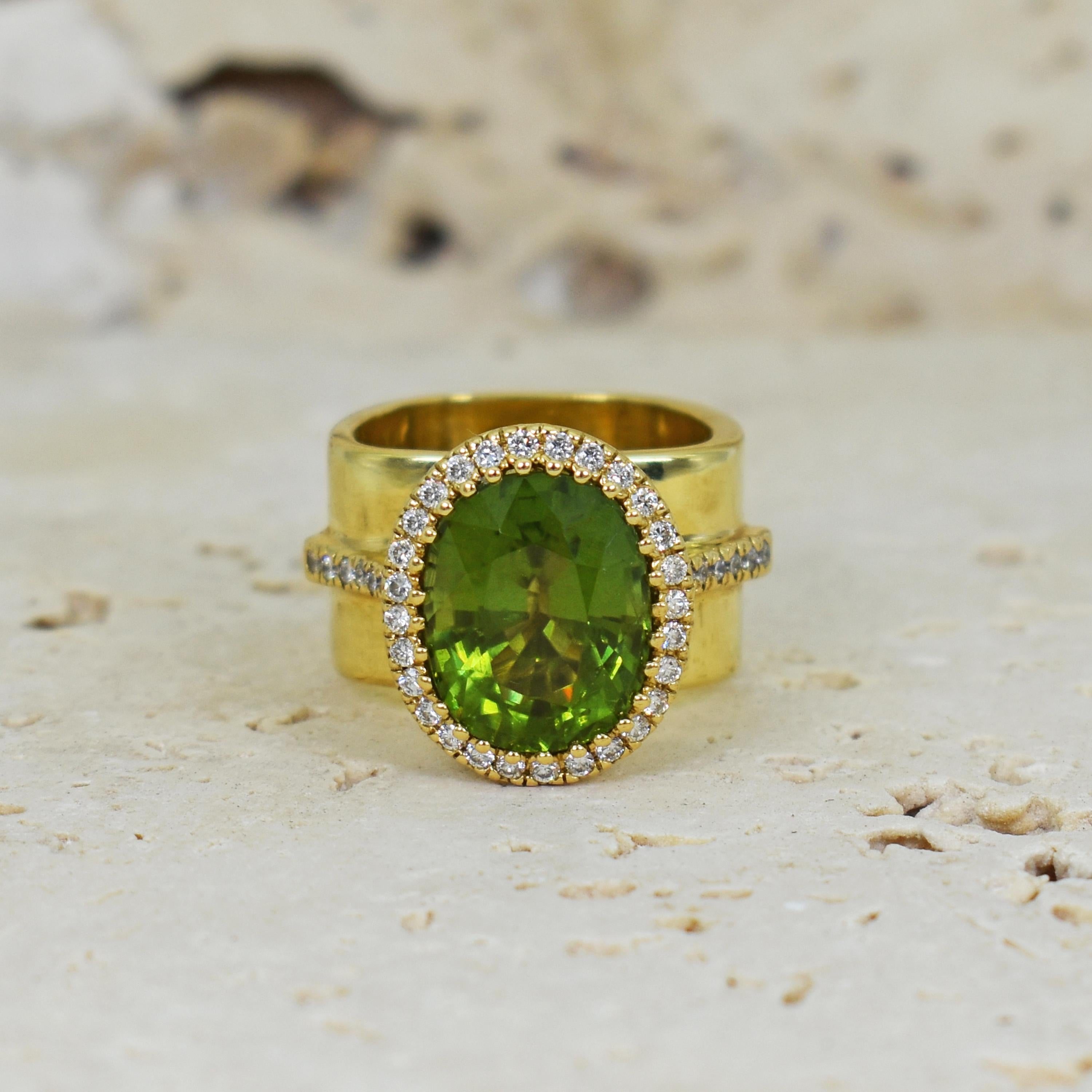 8.49 carat oval Burmese Peridot with Diamond halo and side accents (weighing a total of .55 carat, SI1 in clarity, G in color) set in 18k yellow gold with scalloped undercarriage on a solid 18k yellow gold square band. Size 7. Gorgeous Burma Peridot