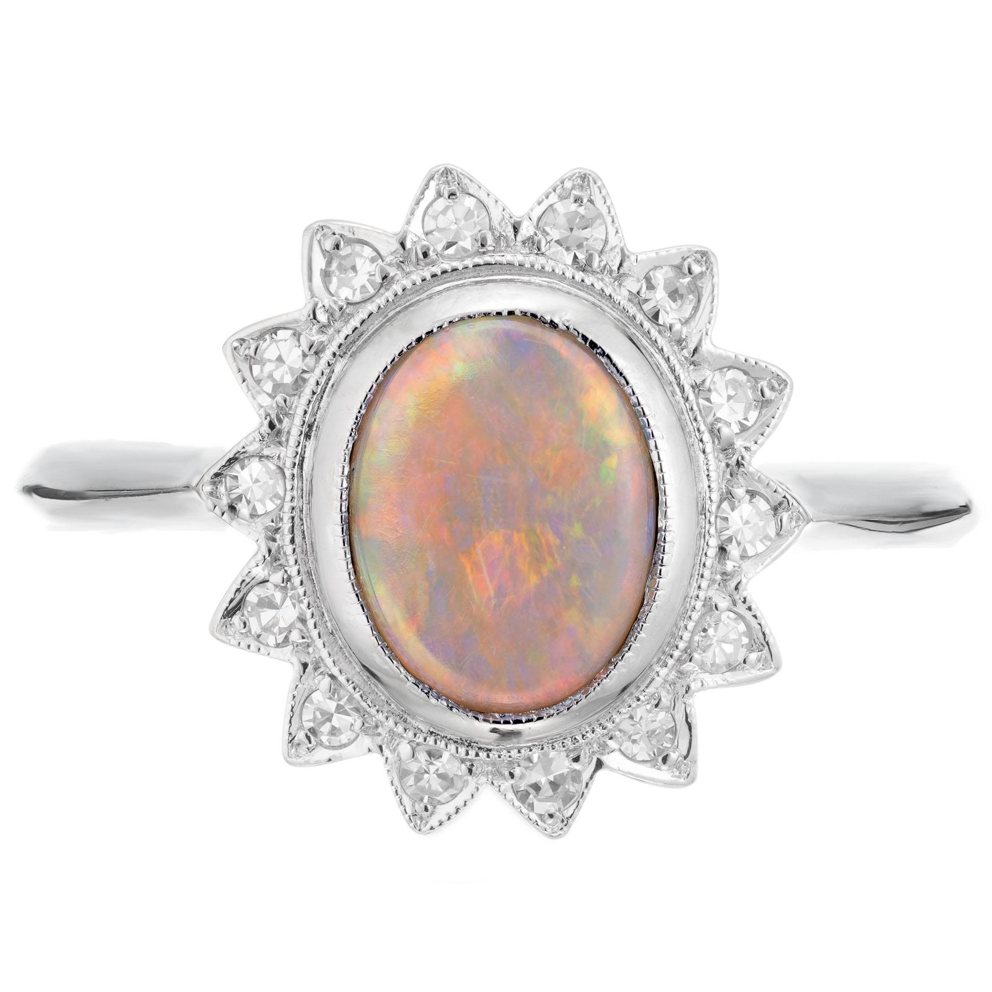 Mid-century 1950's opal and diamond ring. 14k white gold setting with a .85cts oval center opal and a halo of round cut diamonds. The opal has flashes of red, orange, blue and green.

1 oval fine blue, green, orange, and red Opal, approx. total