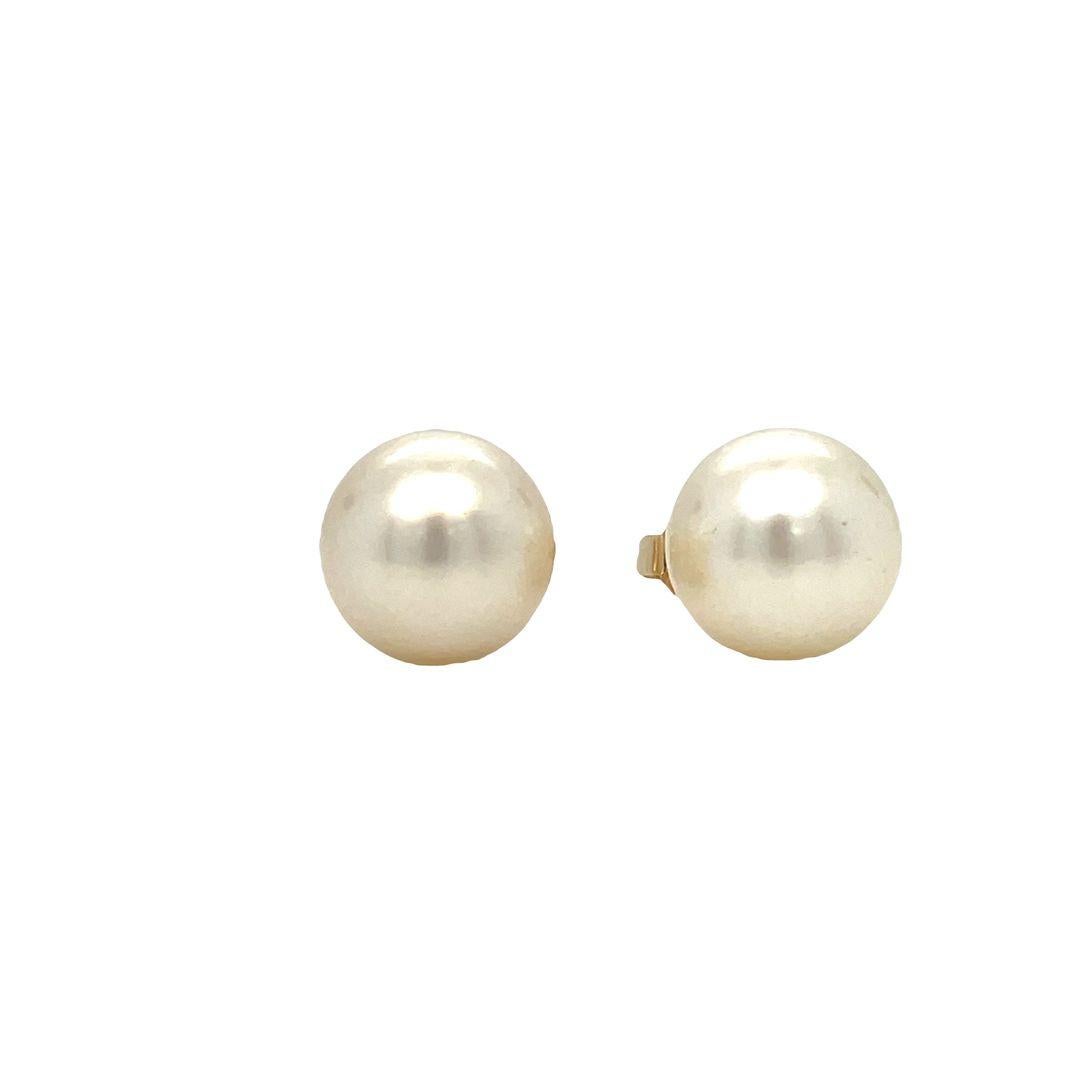 A classic 14k yellow gold pair of pearl stud earrings. The perfect accessory to dress up any outfit is this pair of 8.5 mm pearl studs. They are perfect round pearls with perfect classic white in color. They are set in 14k Yellow gold with and