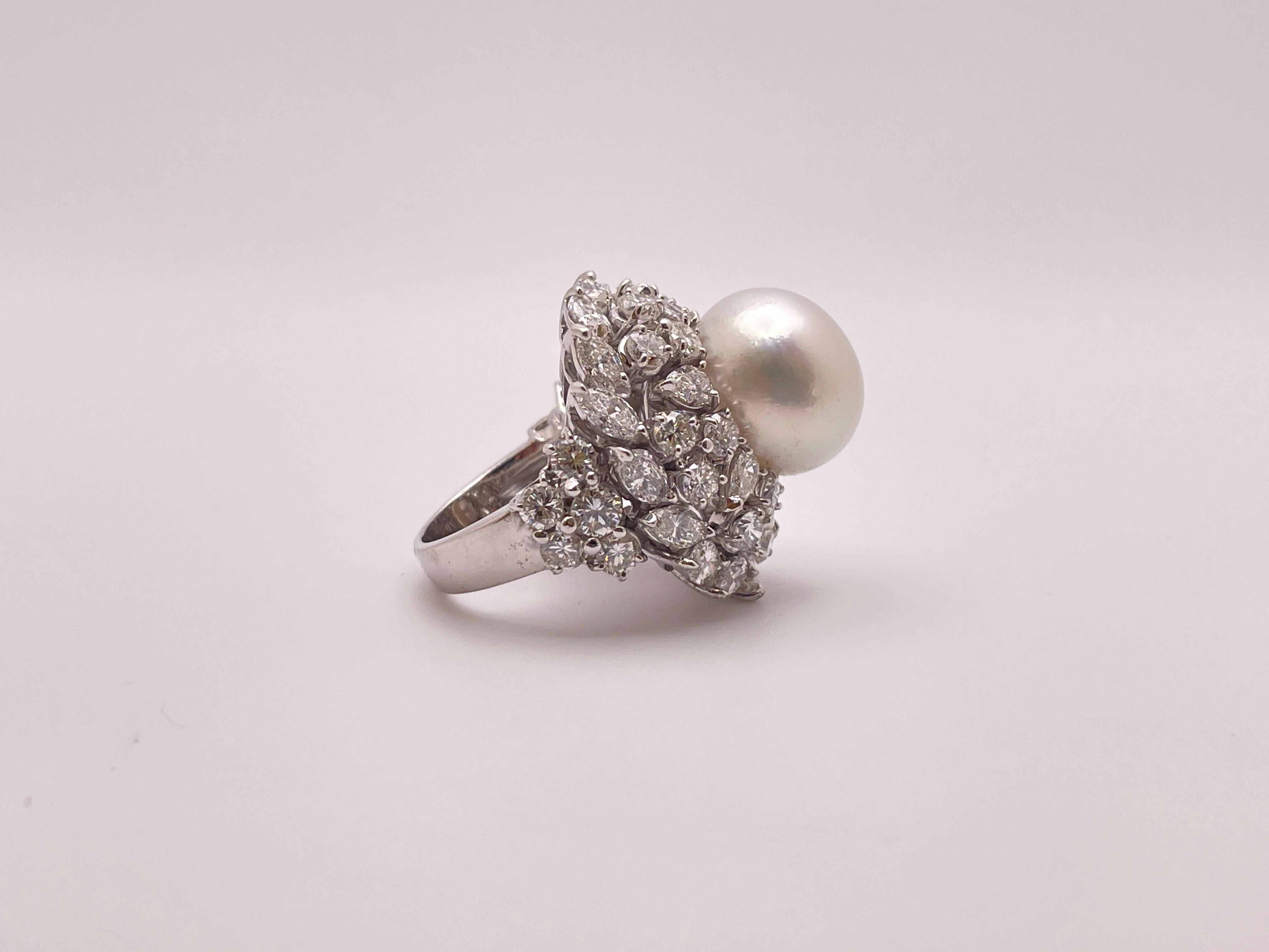 Uno straordinario anello da cocktail in oro bianco 18 carati con diamanti e perle in stile ballerina. Al centro una magnifica perla naturale dei mari del sud a tutto tondo, con un'eccellente lucentezza e nessun difetto visibile, del diametro di