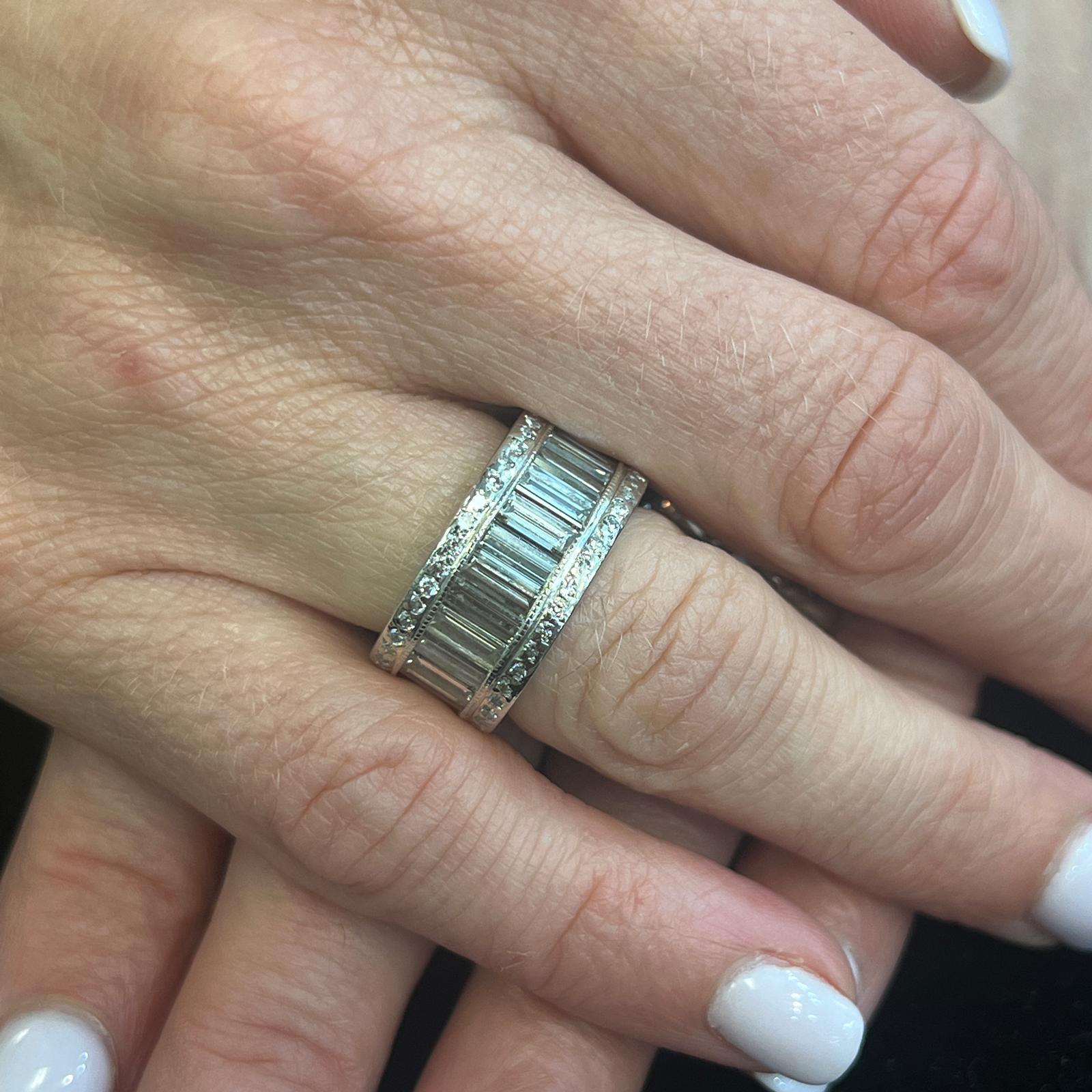 Baguette and round brilliant diamond eternity band handcrafted in platinum. The band features 25 matching baguette diamonds weighing approximately 7.75 CTW. There are two rows of round brilliant cut diamonds weighing .76 CTW. The diamonds (8.51 CTW