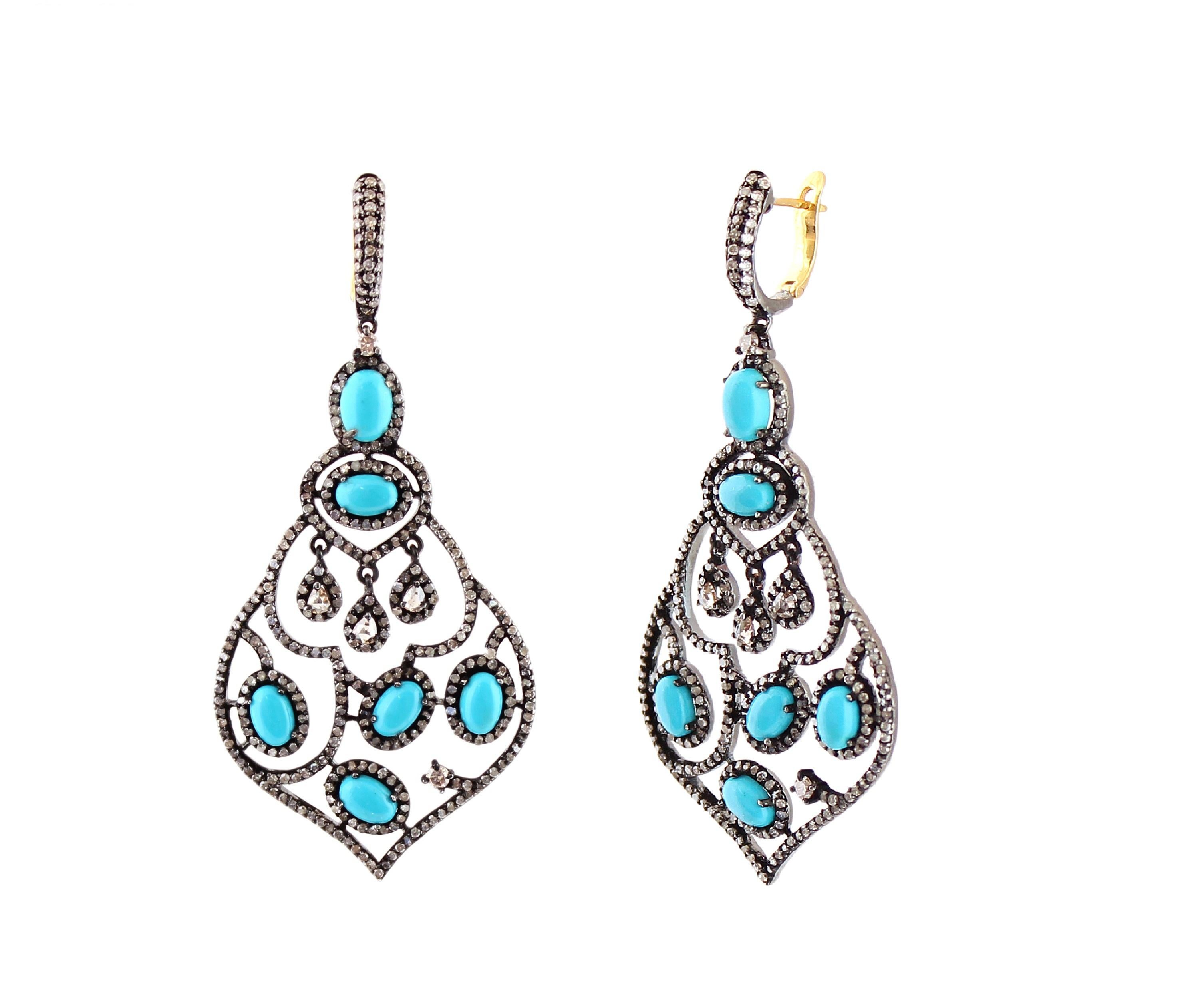 These stunning Victorian chandelier dangle earrings feature 8.51 cts. of diamonds and turquoise in 18k/925 silver. The hoop surmount is studded with diamonds and the drop beneath it, is nature-inspired with floral forms. Turquoise oval cabs 