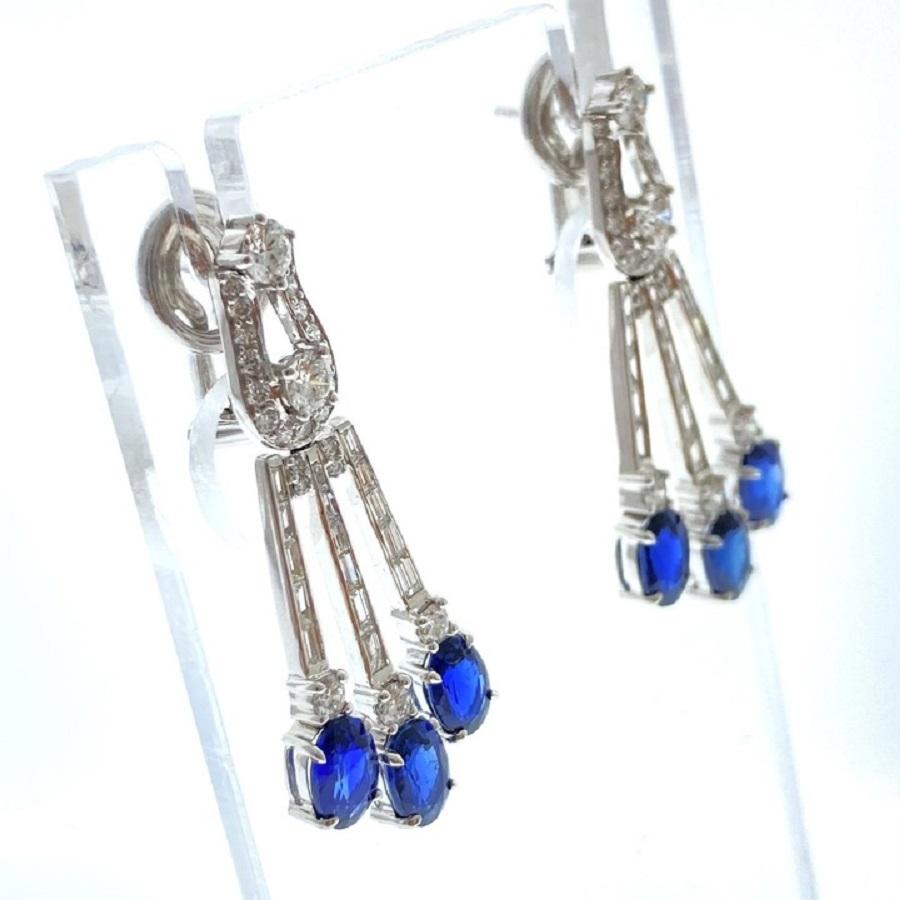Élevez votre élégance avec ces superbes boucles d'oreilles, ornées de deux saphirs bleus exquis de forme ovale d'un poids total en carats de 8,52. Chaque saphir est entouré de 120 diamants ronds et baguettes, d'un poids total de 3,05 carats, créant