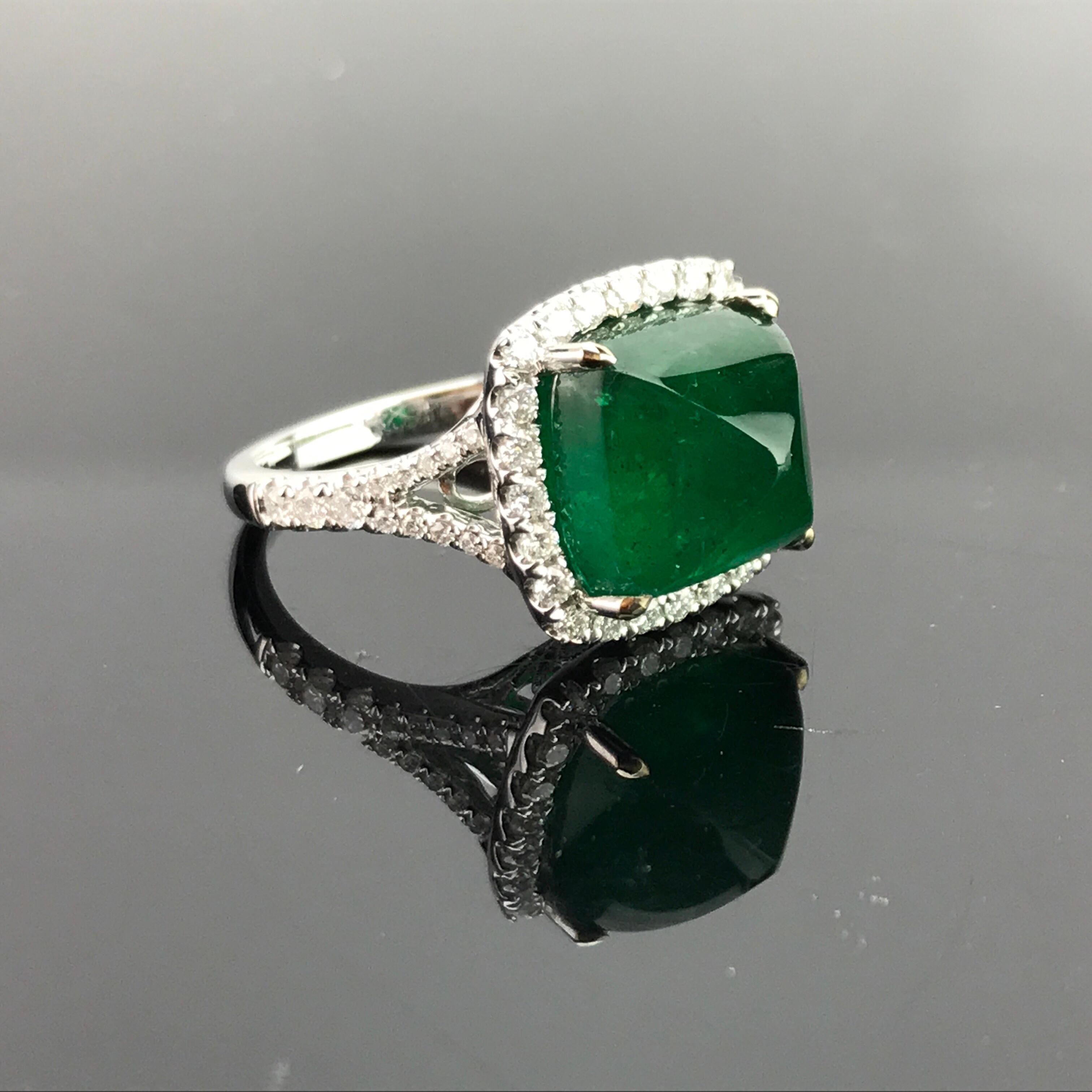 A one of a kind, 8.54 carat deep-green Emerald sugarloaf sorrounded with a White Diamond halo, all set in a 18K white gold band.

Stone Details: 
Stone: Zambian Emerald
Cut: Sugarloaf
Carat Weight: 8.54

Diamond Details:
Cut: Brilliant
Total Carat