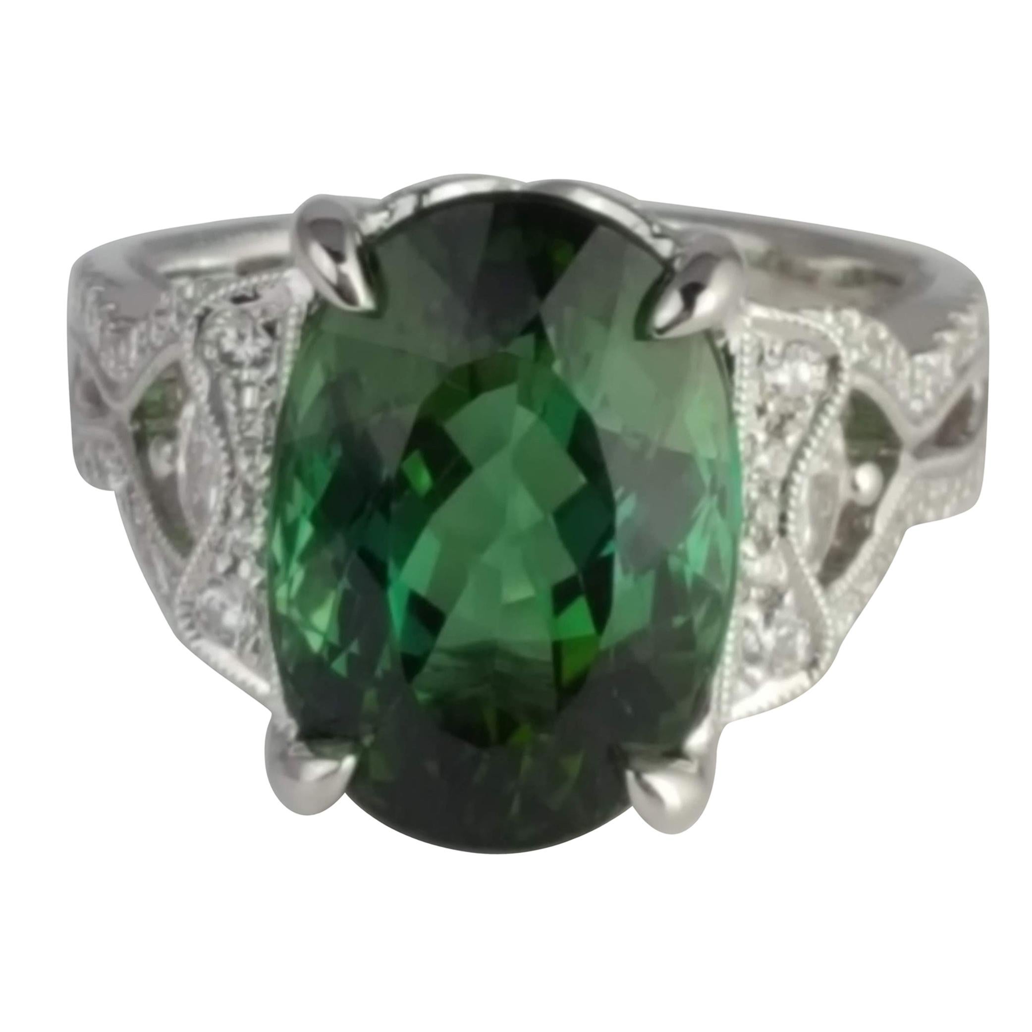 With an 8.54 carat oval cut exotic green Tourmaline center, and a decorated side shank (total diamond weight 0.51 carats), this ring shines from every angle. Intricate hand engraved milgrain work throughout adds to the charm of the piece.

Center: