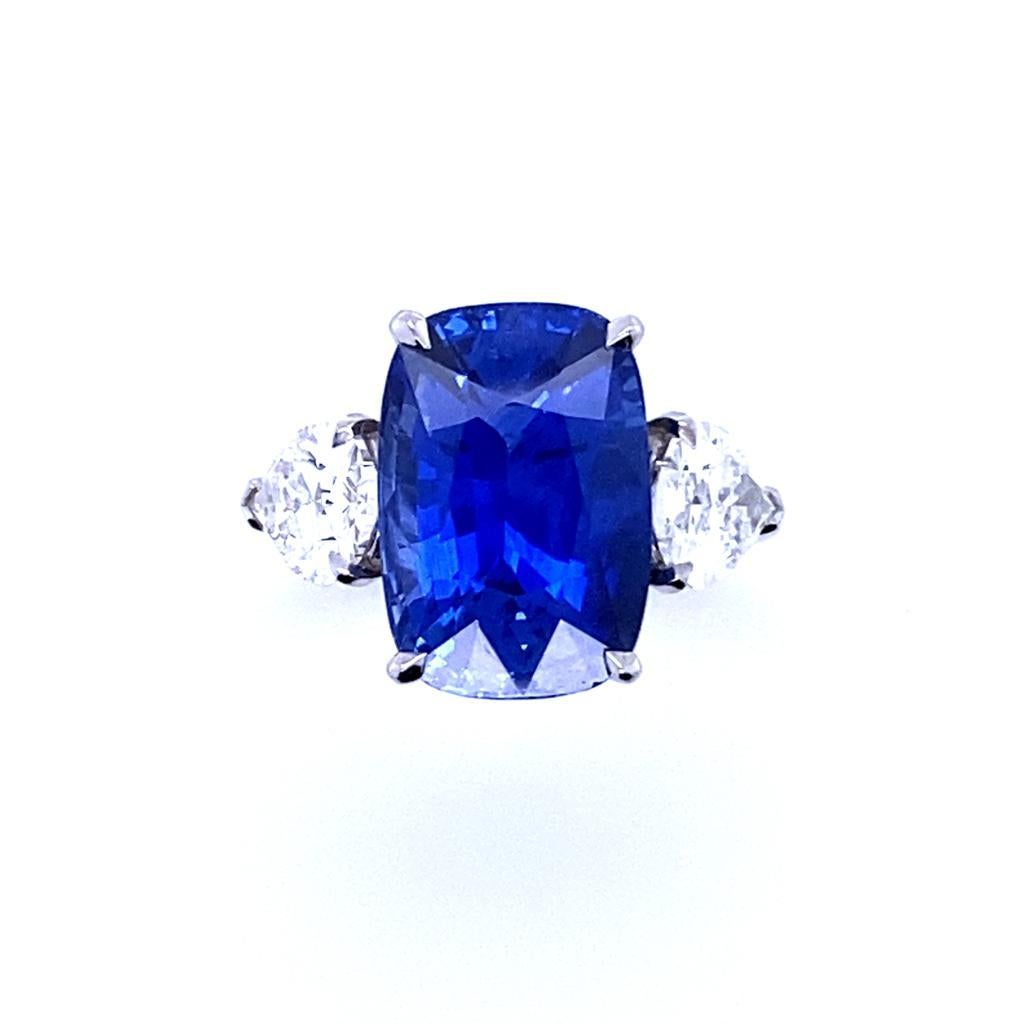 A 8.55 carat sapphire and diamond three stone platinum engagement ring.

This exceptional sapphire and diamond engagement ring is handcrafted in platinum.  
Claw set to its centre with a cushion cut sapphire of 8.55 carats. The stone is a vivid