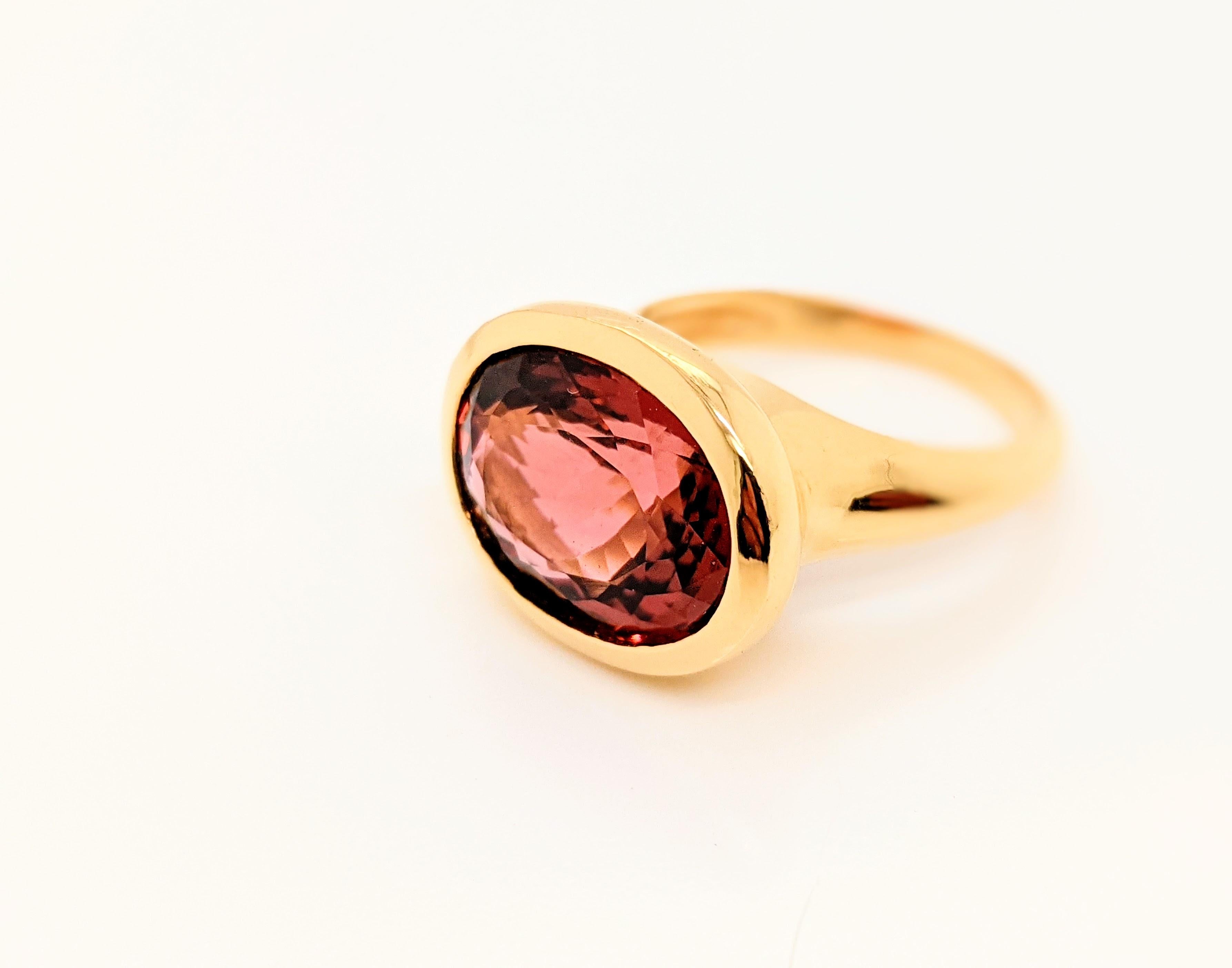 Anello in oro giallo 18k con tormalina ovale naturale rosa/rossa sfaccettata da 8,56 carati.
Il colore intenso e profondo di un ovulo di tormalina rosa naturale tagliato in modo elegante, audace e dalle linee pulite, senza tempo e pronto da