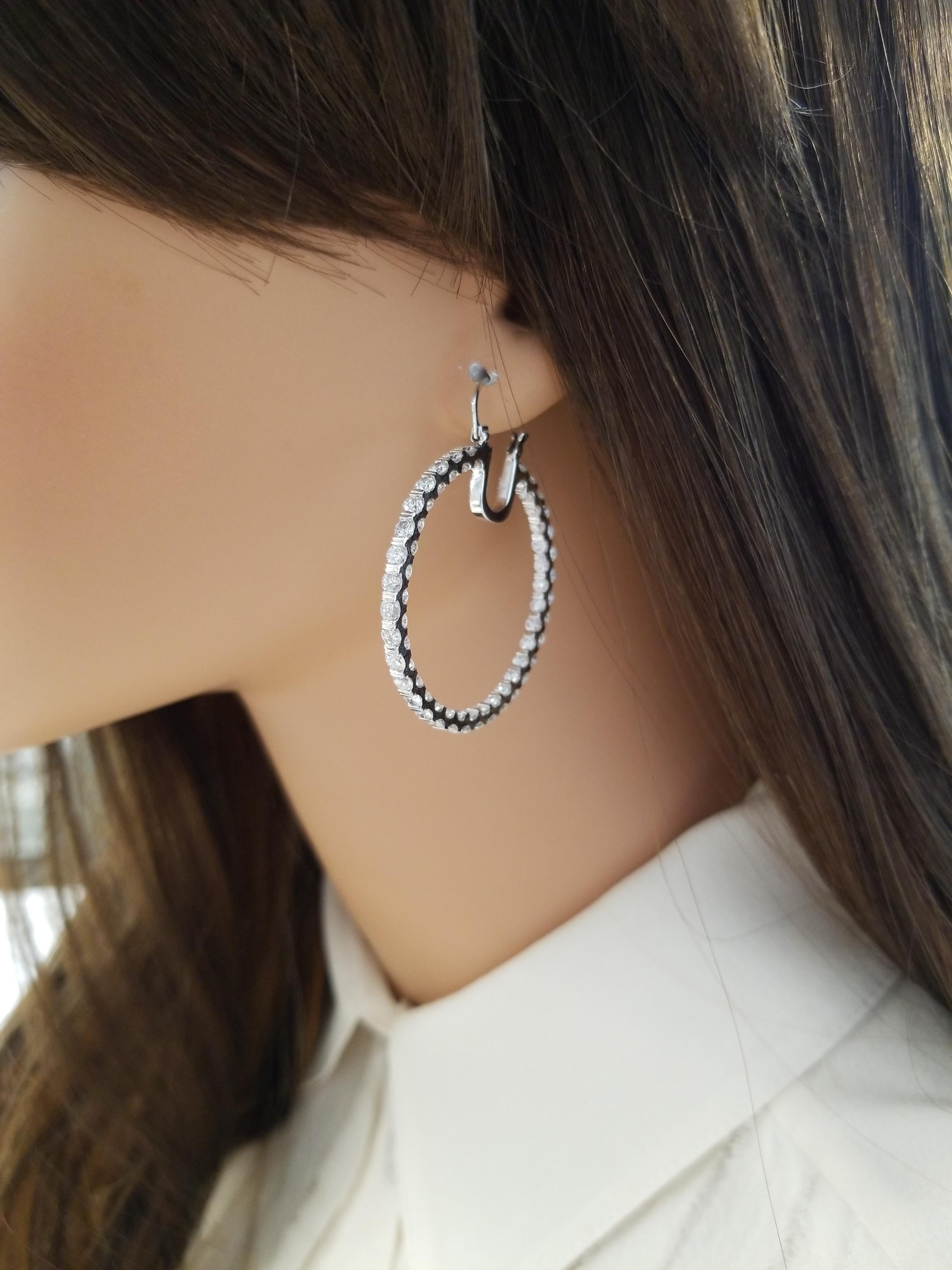 Nothing says luxury like an incredible pair of diamond hoop earrings for that special someone in mind. These stunning brightly polished 14 karat white gold inside out hoop earrings feature a total of 160 round brilliant cut diamonds prong set on the
