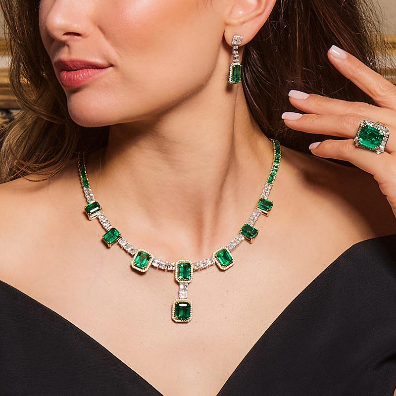 The Art Deco styled Grand Emerald & Diamond Necklace is a breathtaking statement piece crafted in 18k white and yellow gold. It showcases large, fine emerald stones at the front, seamlessly connected by GIA-certified diamonds, with rich green