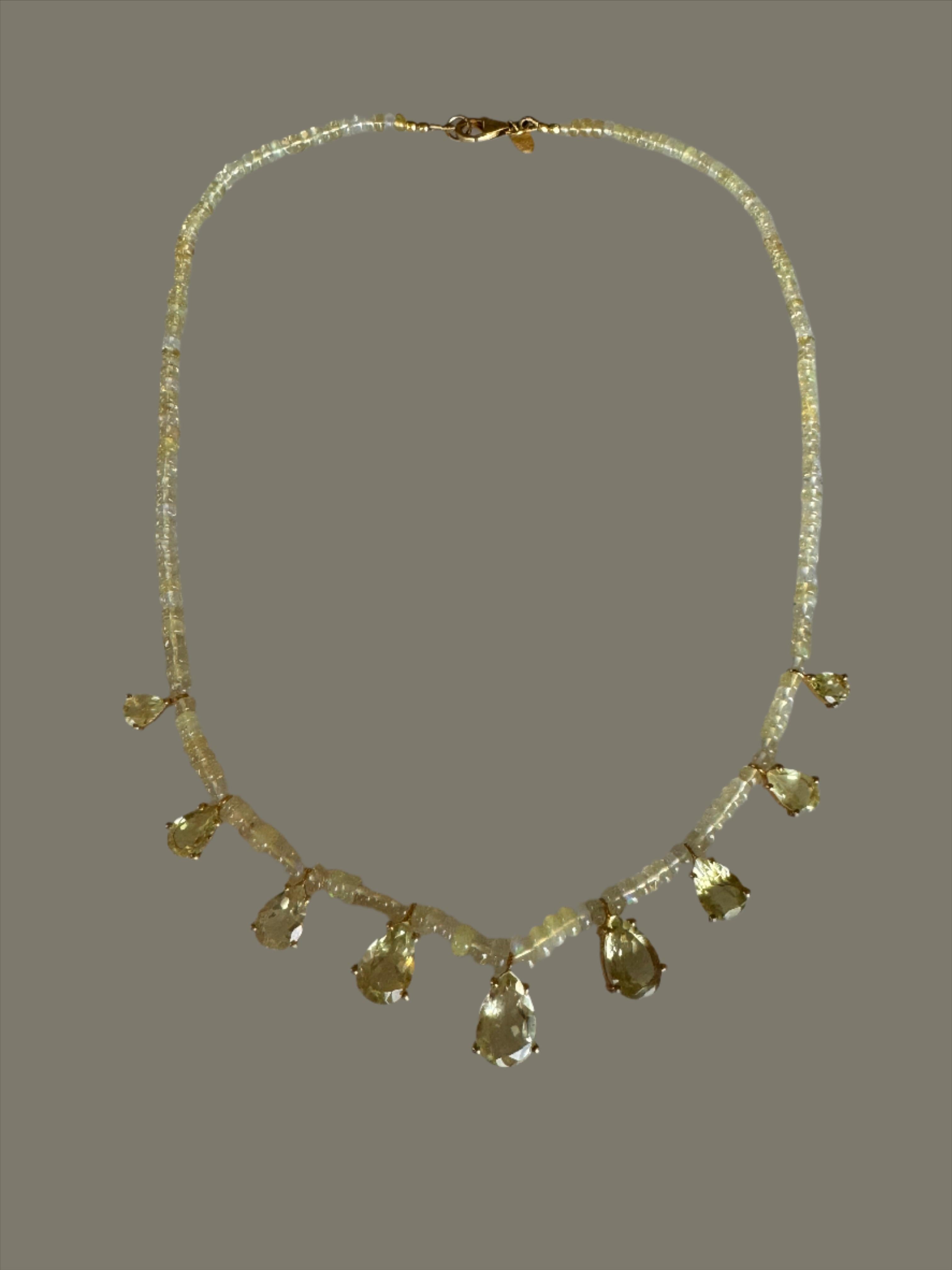 This gorgeous Opal and Lemon Topaz beaded necklace is comprised of 9 pear cut Lemon Topaz stones that are weighing over 20 carats. They are set in 14K matte gold plating which displays soft hues and tones of gold. The setting is minimal allowing for