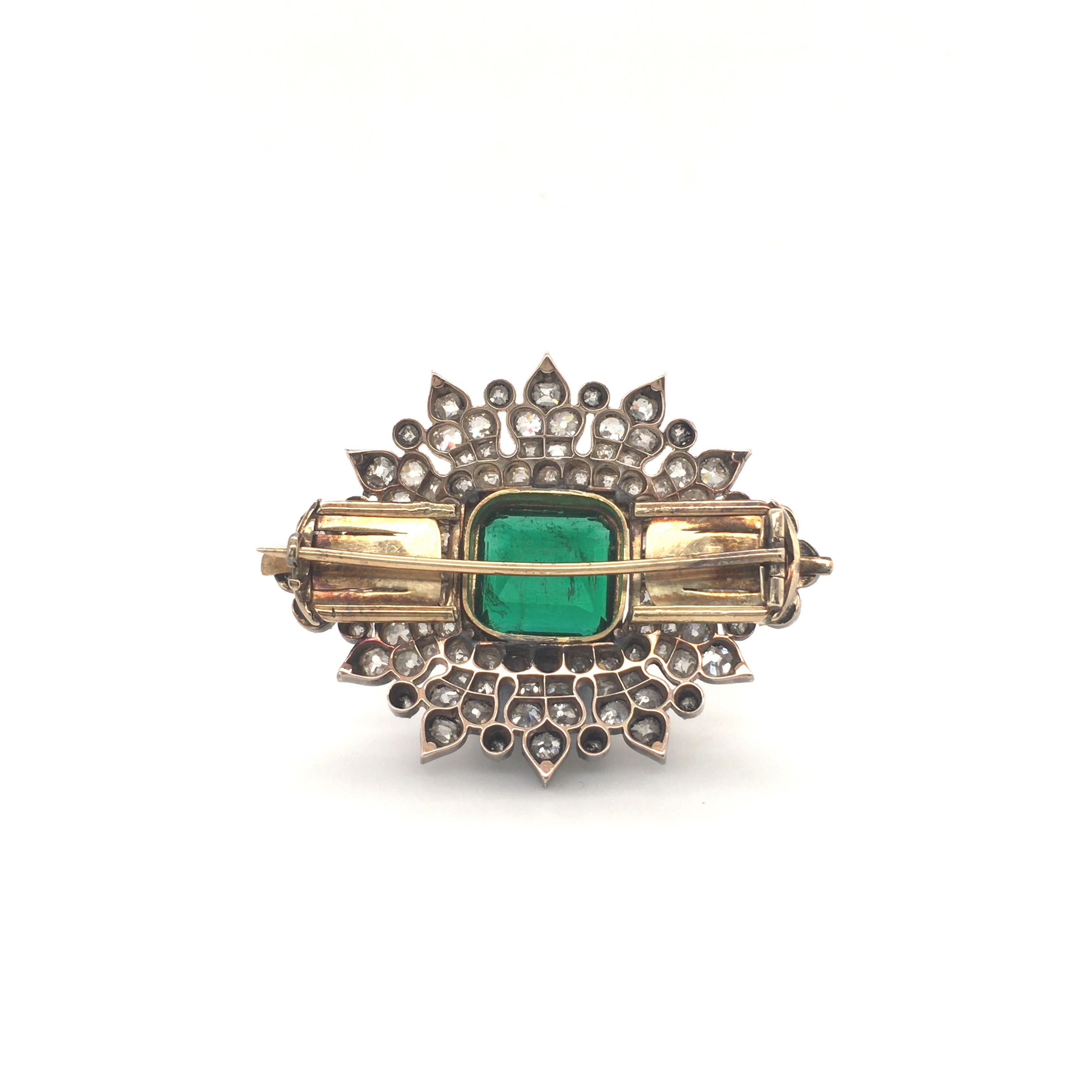 Striking vintage style brooch from our special Haruni atelier holding a 8.60 carat emerald at its centre set in yellow gold, surrounded by 108 delicate old cut diamonds with an approximate total weight of 7.64 carat. This shimmering brooch is the