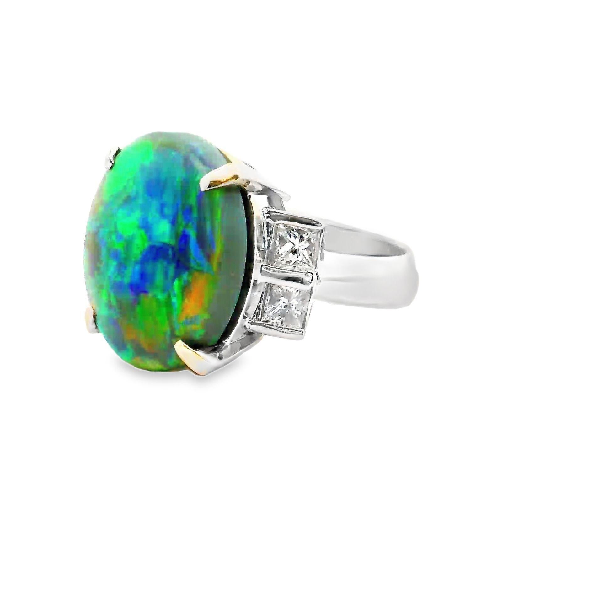 A large and impressive natural Australian opal weighing 8.62 carats takes center stage. It has excellent play-of-color as large and vibrant flashes of color pop off the stones surface as it is moved in the light. The colors include green, yellow,