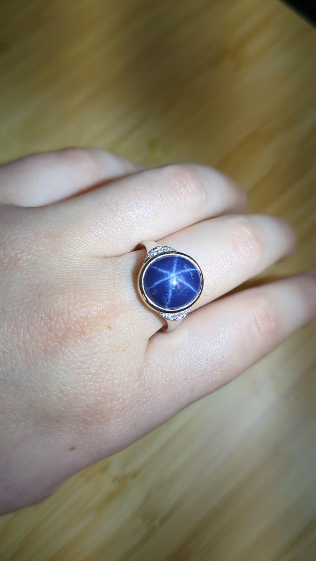 Questo elegante anello mette in mostra uno zaffiro ovale di Ceylon da 8,57 carati e misura 12,7x11 mm. Incastonata in oro 14k (3,39g), l'affascinante pietra centrale presenta un fenomeno stellare naturale noto come asterismo. Dieci diamanti