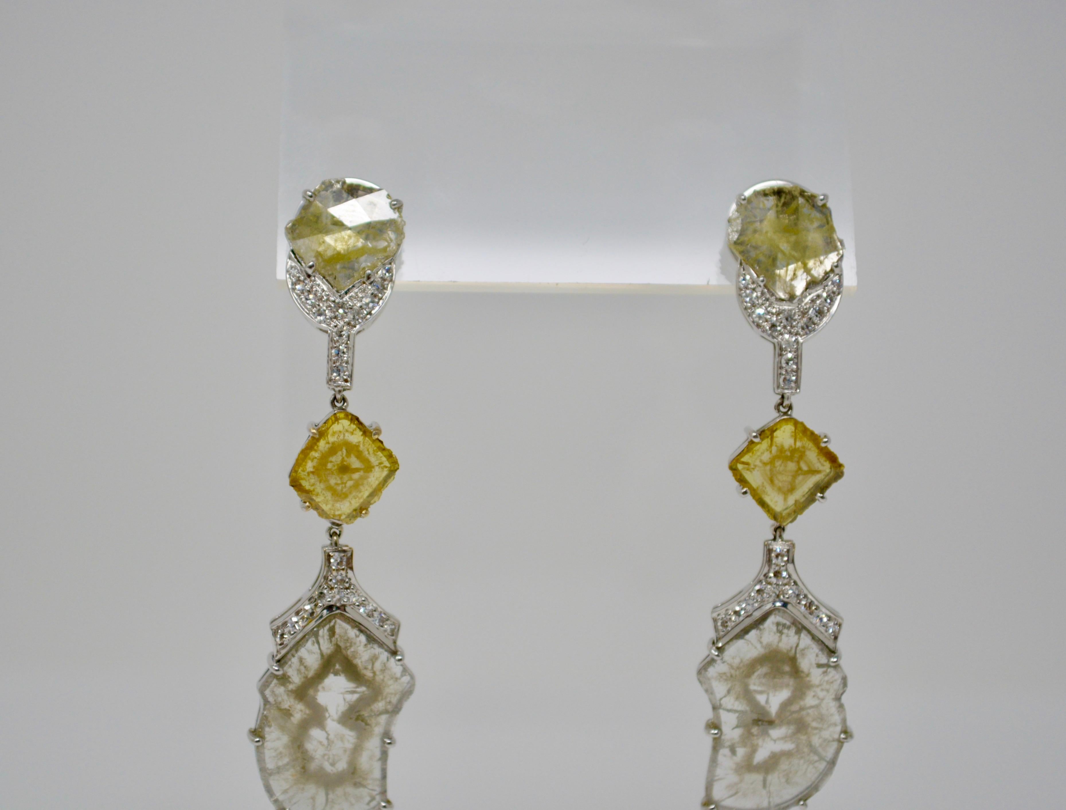 These beautiful natural fancy color diamond earring features natural yellow and gray slice diamonds weighing 8.33 carat and white round brilliant diamond melees weighing 0.37 carat. These earrings look extremely attractive, elegant and classy. 
They