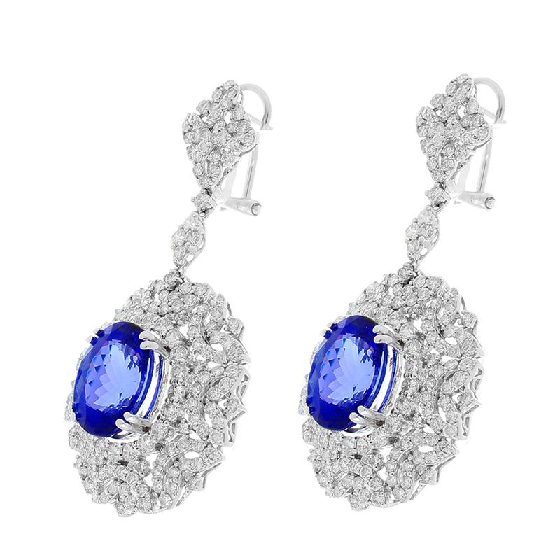 These earrings swing and glow like chandeliers in the finest hotel. Originated from the foothills of Mt. Kilimajaro in Tanzania, 8.70 carats of deep blue tanzanite are delicately prong set within a dazzling array of 6.03 carats of brilliant