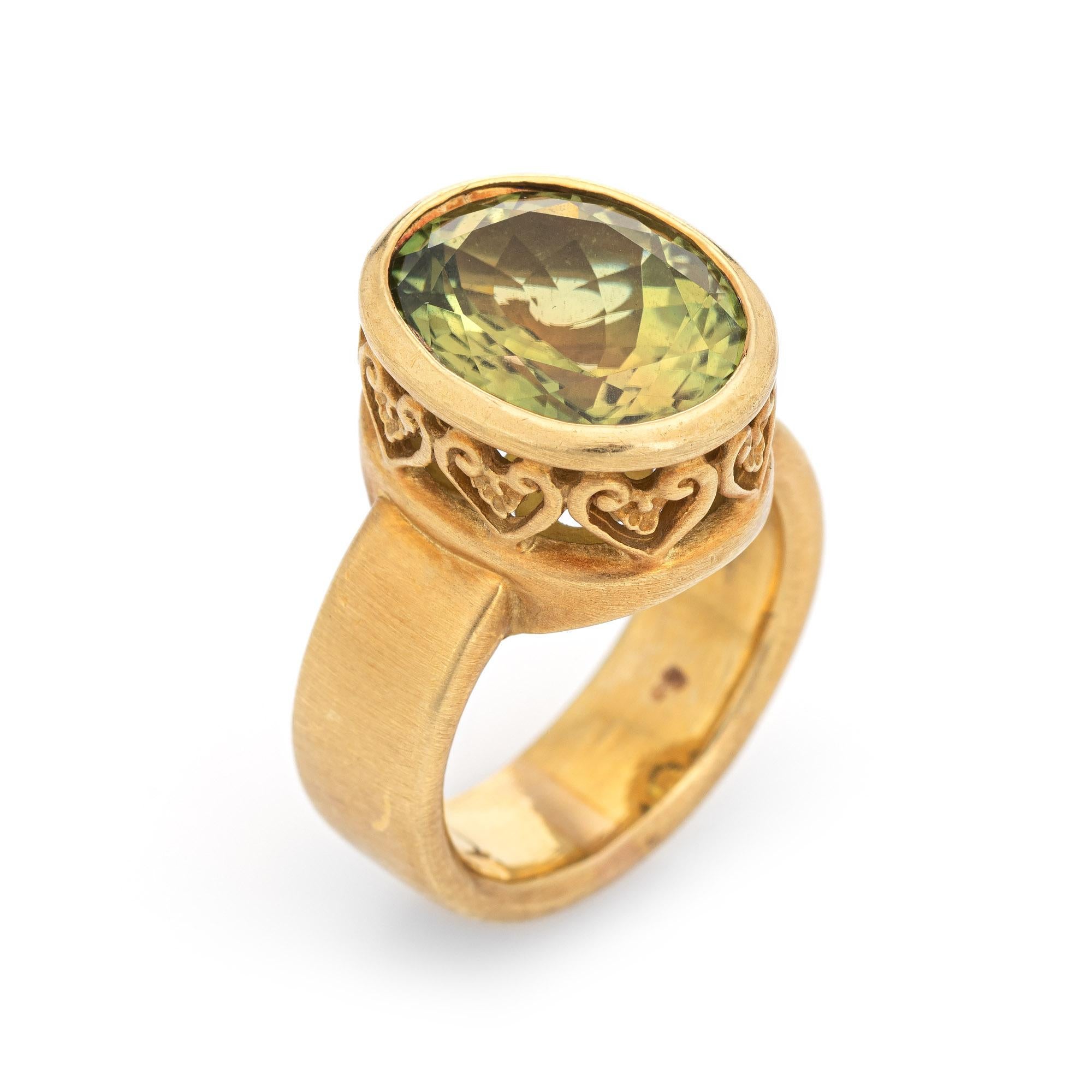Stylish estate olive green tourmaline cocktail ring crafted in 18 karat yellow gold. 

Mixed cut tourmaline measures 15.2 x 12.2 x 7.0mm (estimated at 8.70 carats). The tourmaline is in excellent condition and free of cracks or chips. 

The olive