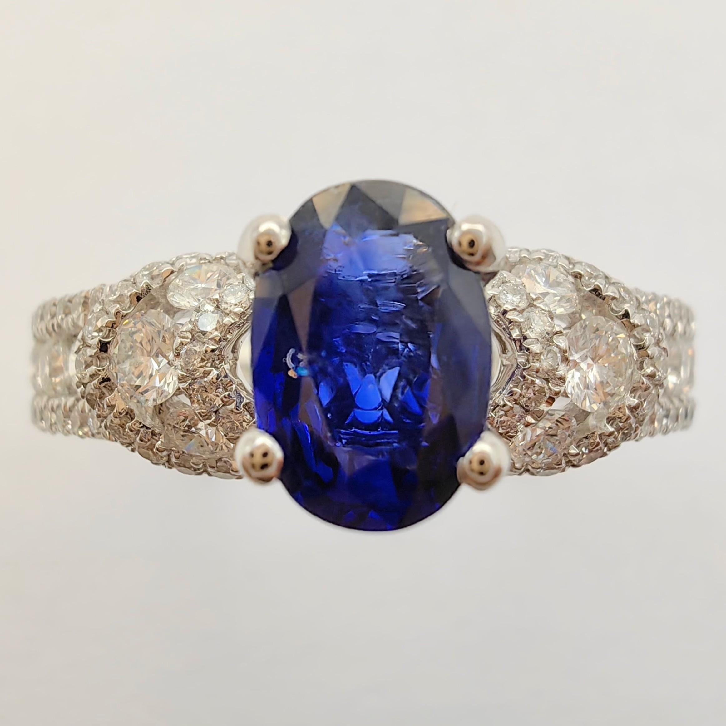 Wir präsentieren unseren atemberaubenden .88 Karat Oval-Cut Sapphire 88 Diamond Cluster Ring in 18k Weißgold. Dieses exquisite Schmuckstück ist ein wahres Zeugnis von Raffinesse und Eleganz. Dieser atemberaubende Ring wurde mit Präzision und