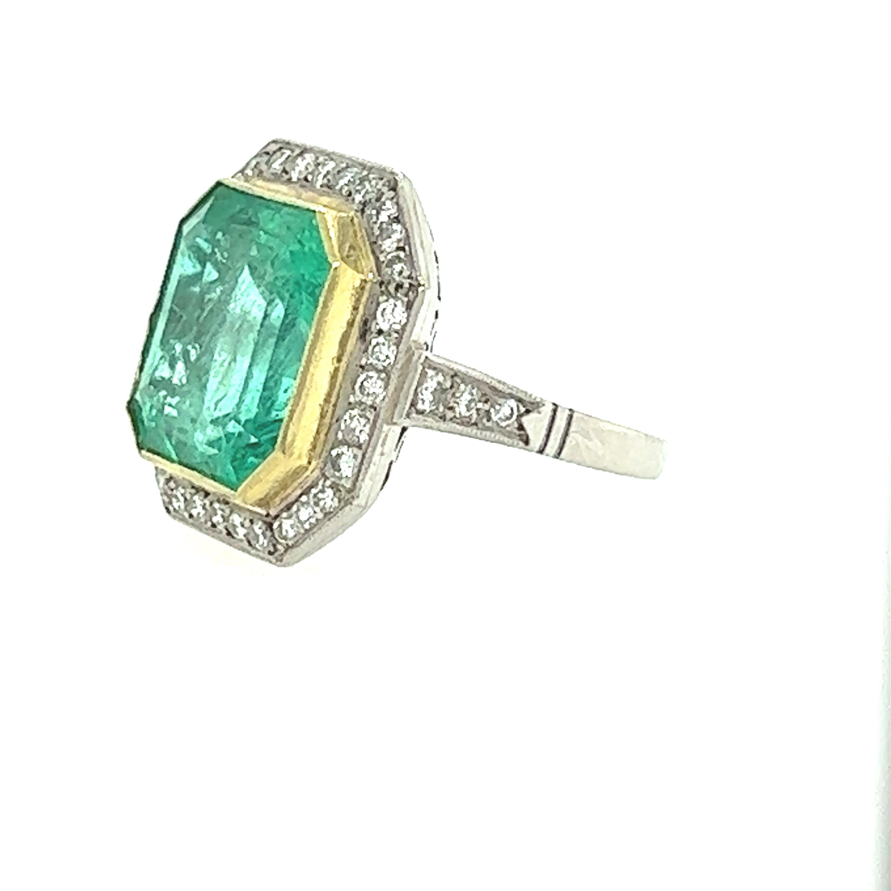 This breathtaking Art Deco style ring features a stunning 8.80 carat Columbian emerald at its center, surrounded by a glittering halo of 1.00 carats of diamonds. The platinum band of the ring is designed to showcase the timeless elegance of the Art