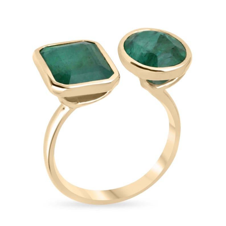 Dieser exquisite Ring von Toi et Moi zeigt zwei atemberaubende Smaragde - einen im Ovalschliff und einen im Smaragdschliff -, die beide durch ihren dunkelgrünen Farbton und ihre halbtransparente Klarheit bestechen. Jeder Smaragd ist elegant in eine
