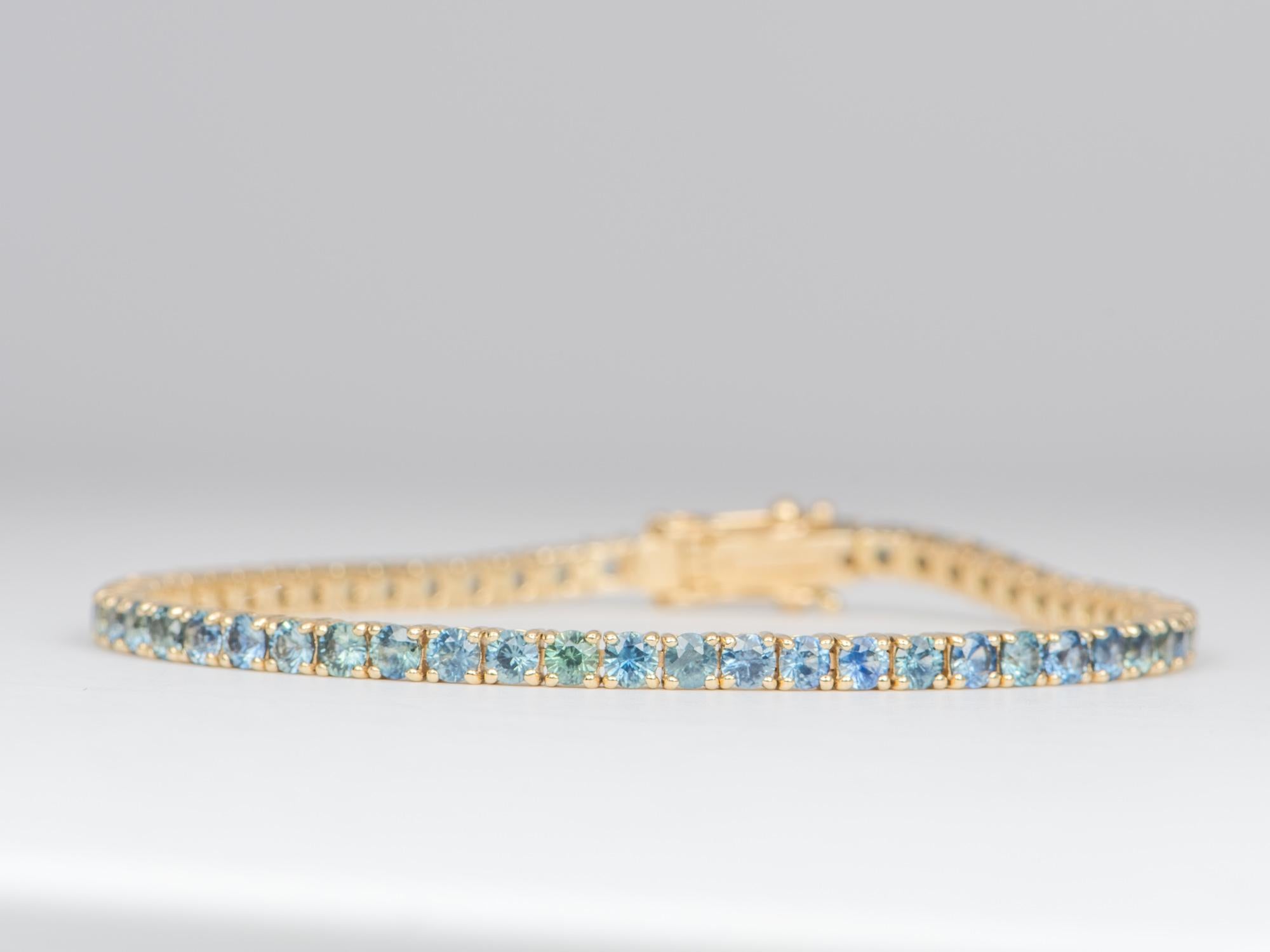 ♥♥ You are buying the Yellow Gold bracelet seen in the photos.

♥ Featuring over 11 grams of solid gold and 8.85ct worth of Montana sapphires, this beautiful bracelet is lined with ombré-colored Montana sapphires ranging from light blue to saturated