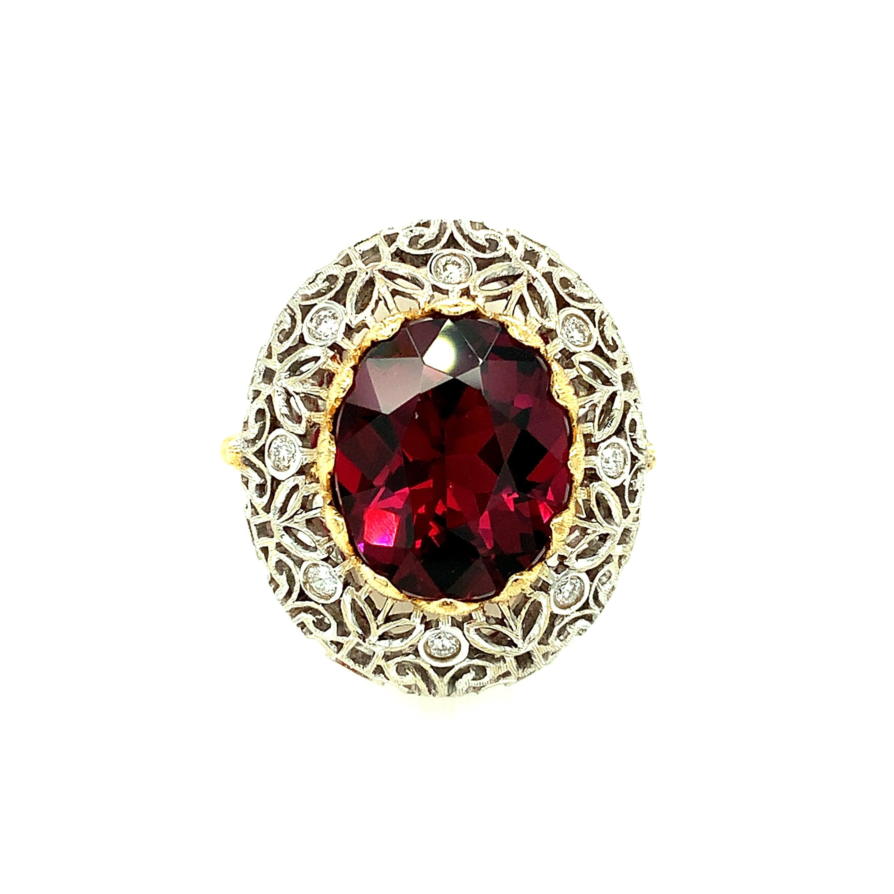 A stunning 8.98 carat oval rhodolite garnet is featured in this handmade, 18k yellow and white gold diamond cocktail ring. The center gemstone has deep, rich, pinkish red wine color (purplish pink, depending on the light). It is mounted in an