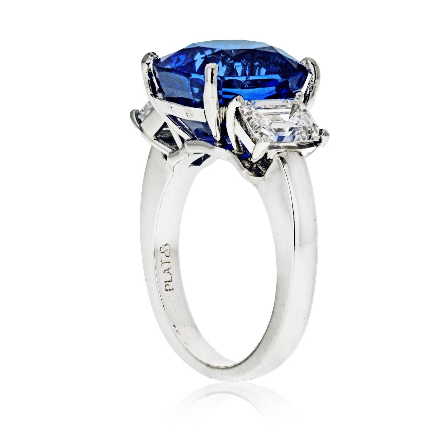 This stunning 8.86 carat blue sapphire and diamond three-stone ring is crafted in luxurious platinum. 

Showcasing a cushion-shaped all-natural, no heat, no treatment blue sapphire weighing 8.86 carats, and accompanied by its AGL lab report.