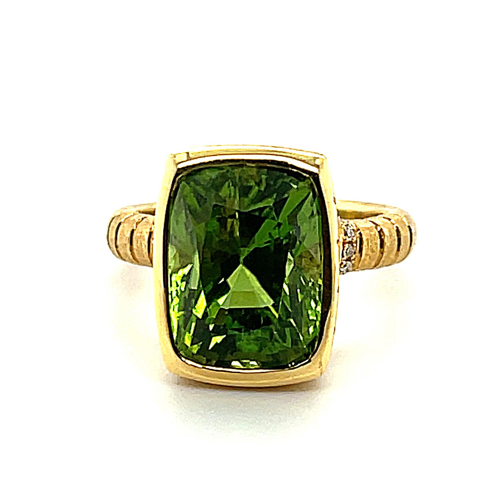 This sleekly stylized ring features a gorgeous 8.88 carat cushion-cut peridot set in precious 18k yellow gold, accented with 10 round brilliant cut diamonds! This is one of our handcrafted signature designs that combines the intrinsic beauty of