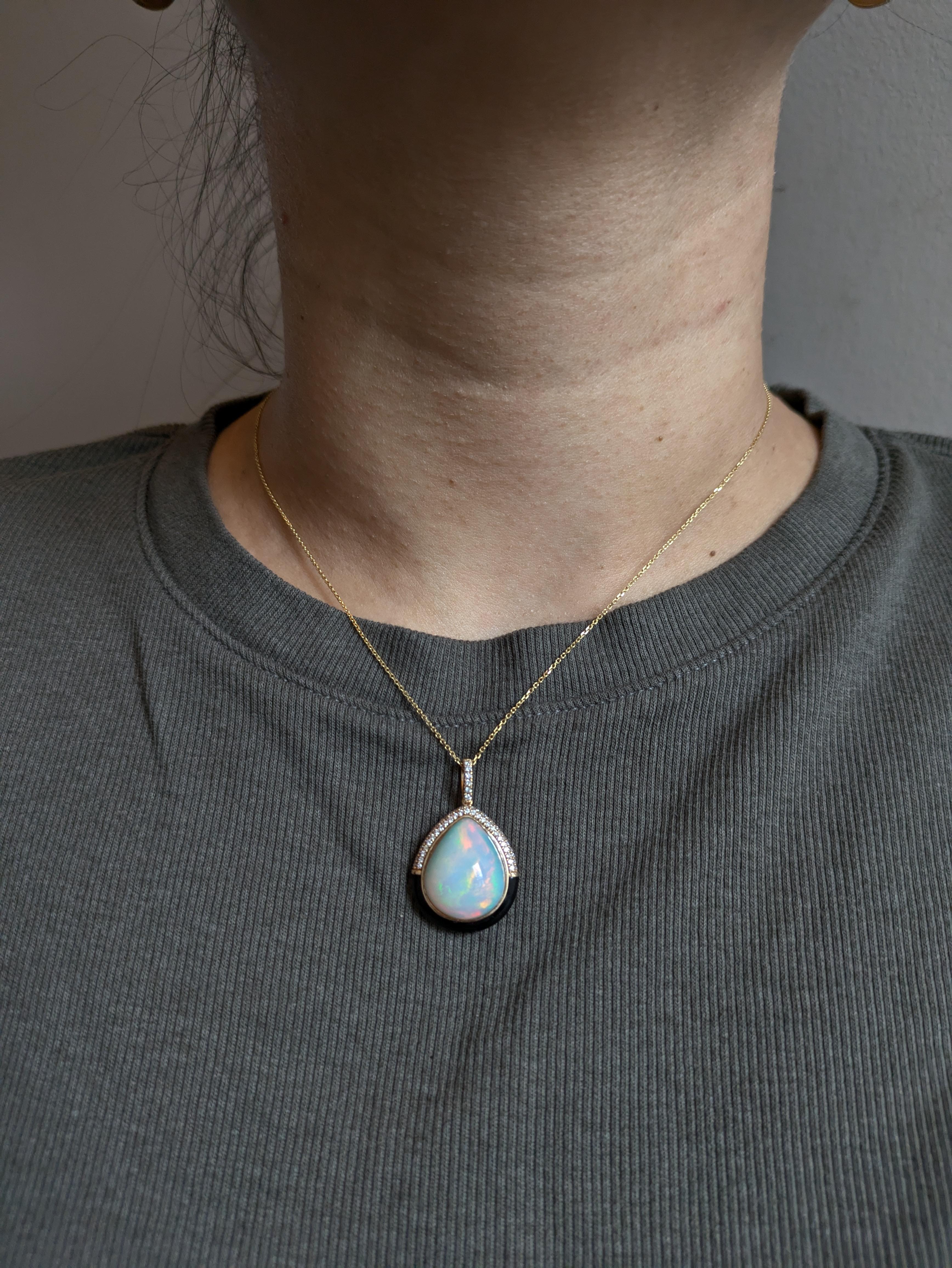 An ethereal 8.83 carat opal floats within a halo of black enamel and radiant earth-mined diamonds, all set in rich 14K real gold. A luxurious piece that brings timeless magic to any collection. This opal pendant also makes a beautiful October
