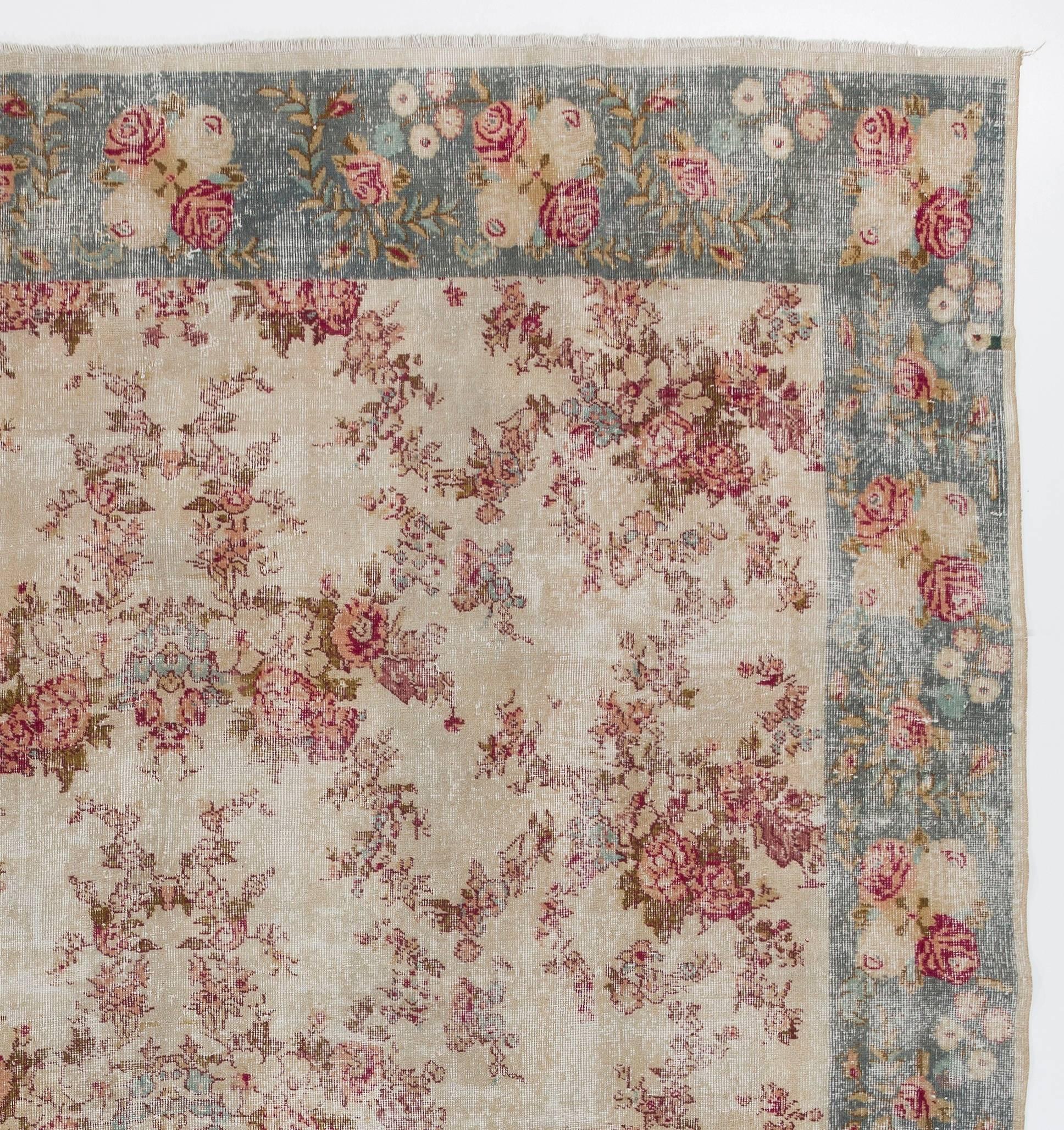 A finely hand-knotted vintage Turkish rug from the 1970s with an overall rose garden design, rendered in soft outlines in romantic reds and pinks reminiscent of the fabrics and flowers of french country and rustic farmhouse styles. The softness of