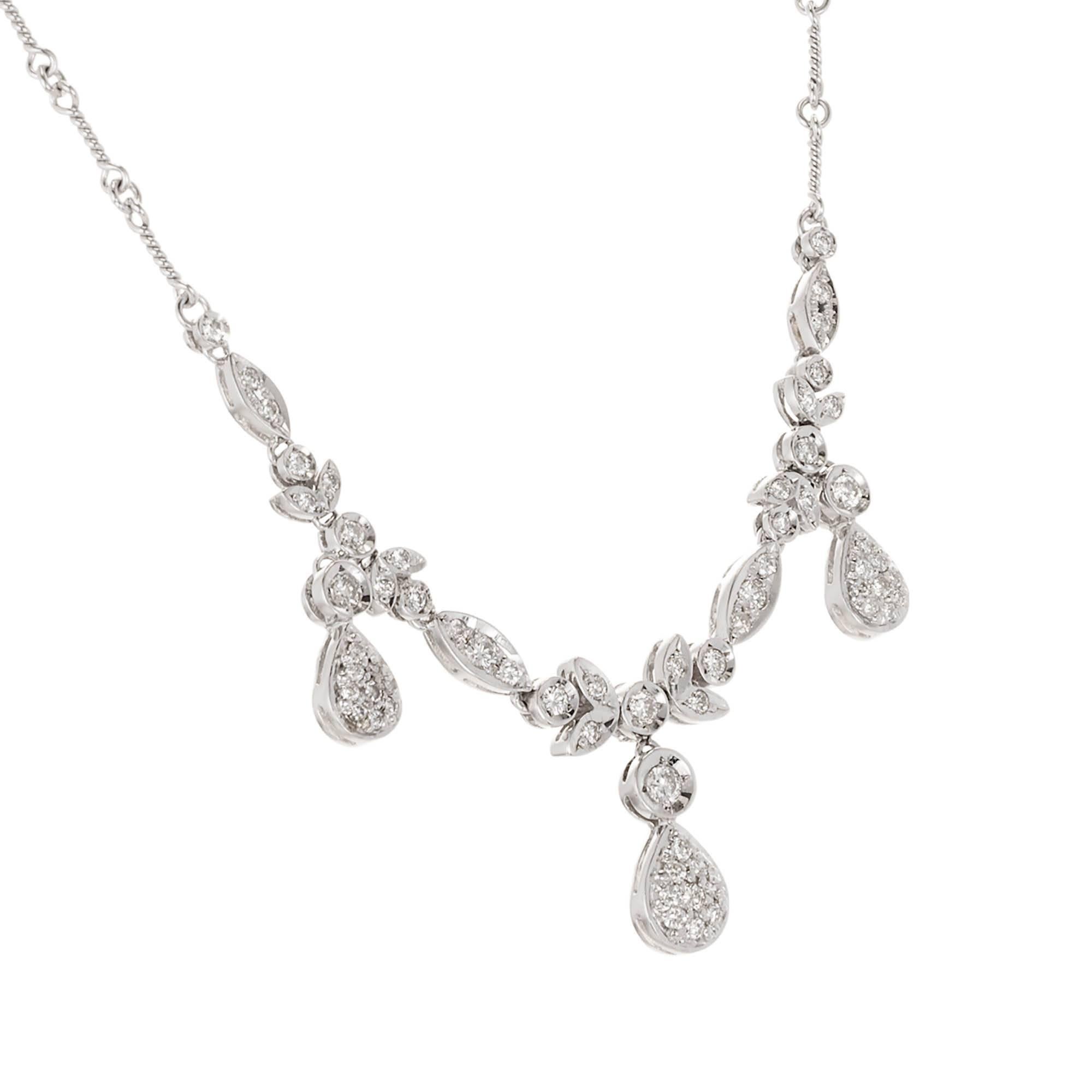 18k white gold and diamond dangle necklace. A coil and link design chain are adorned with a diamond design center. Diamond set petals and marquise shaped links have three separate dangling diamond pave set tear drops hanging with matching sides and