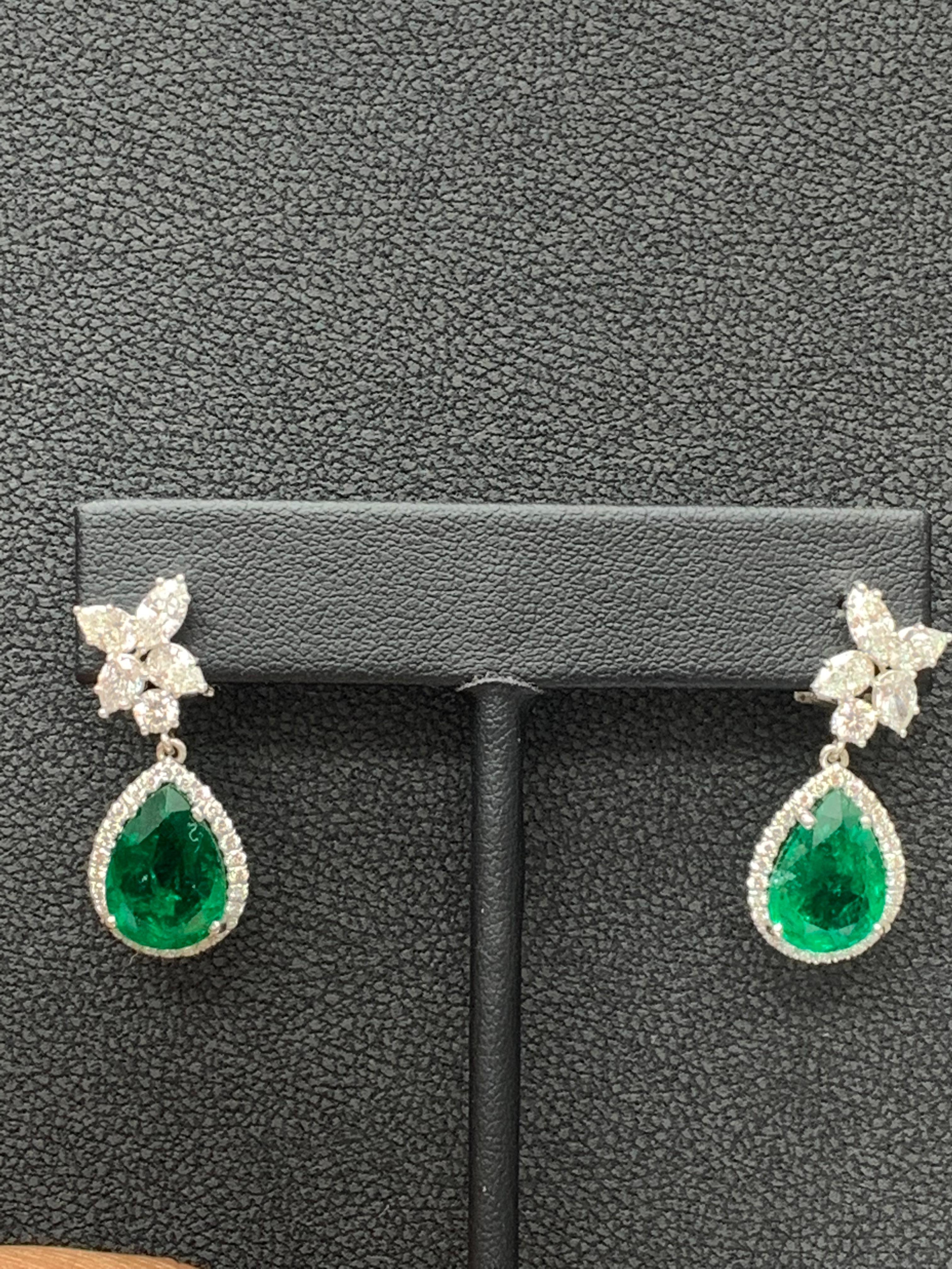 A beautiful and chic pair of drop earrings showcasing a cluster of brilliant mixed-cut diamonds, and pear shape Emerald set in an intricate and stylish design. 8 Mixed cut Diamonds weigh 1.61 carats in total.   2 Emeralds weigh 8.92 carats in total.