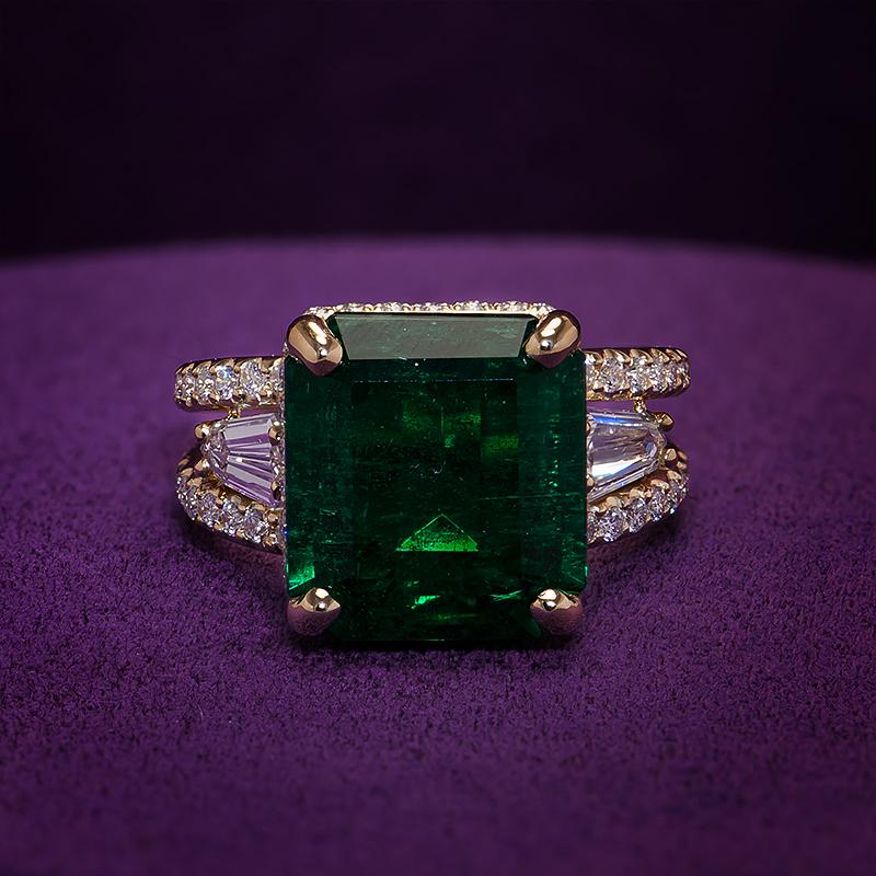 8.94cts Zambian Emerald Ring
This split ring showcases an exquisite 8cts Zambian emerald, held in place by a unique design that gracefully splits the band and embraces the gemstone in a cage of diamonds. The vibrant green of the emerald captures
