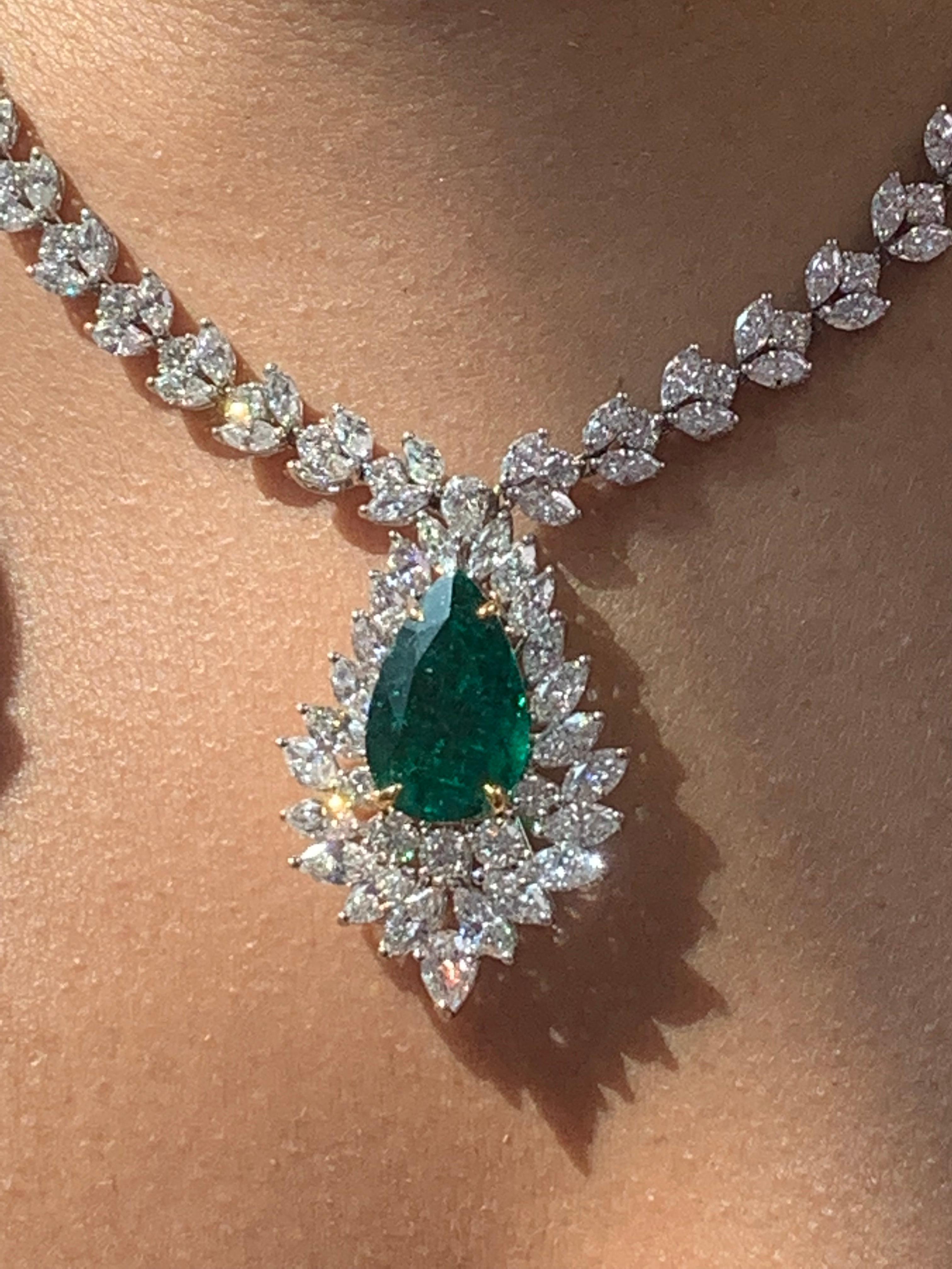 A unique and chic necklace showcasing a drop pendant with an 8.96-carat pear shape emerald, surrounded by Marquise and Round brilliant diamonds. Designed with a young, feminine, and understated woman in mind. A very contemporary aesthetic that
