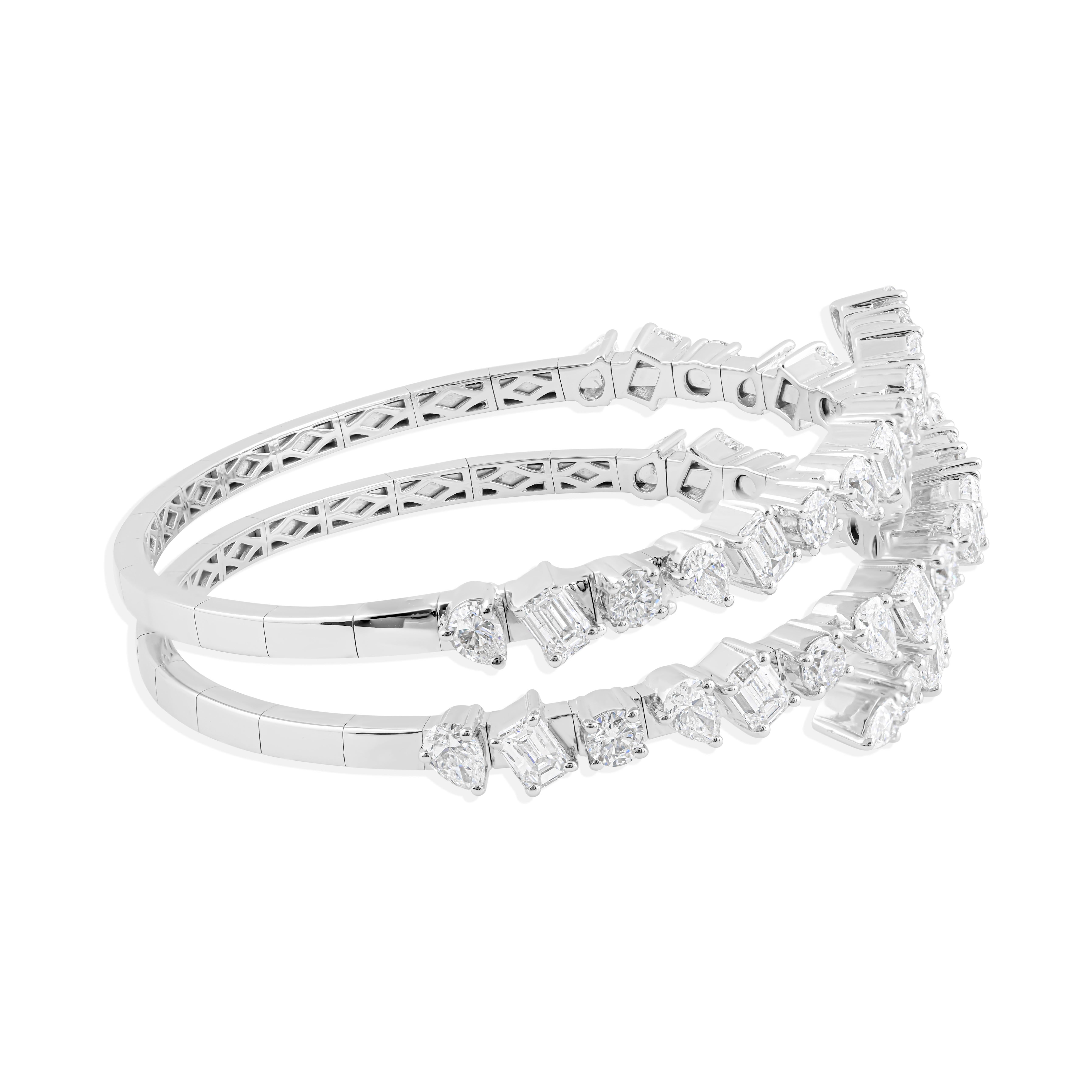 Questo bracciale bangle con spirale di diamanti da 8,99 carati mette in mostra un'affascinante serie di diamanti multiformi con purezza SI e colore H, sapientemente incastonati in oro bianco da 18 carati. Il suo design dinamico a spirale è un pezzo