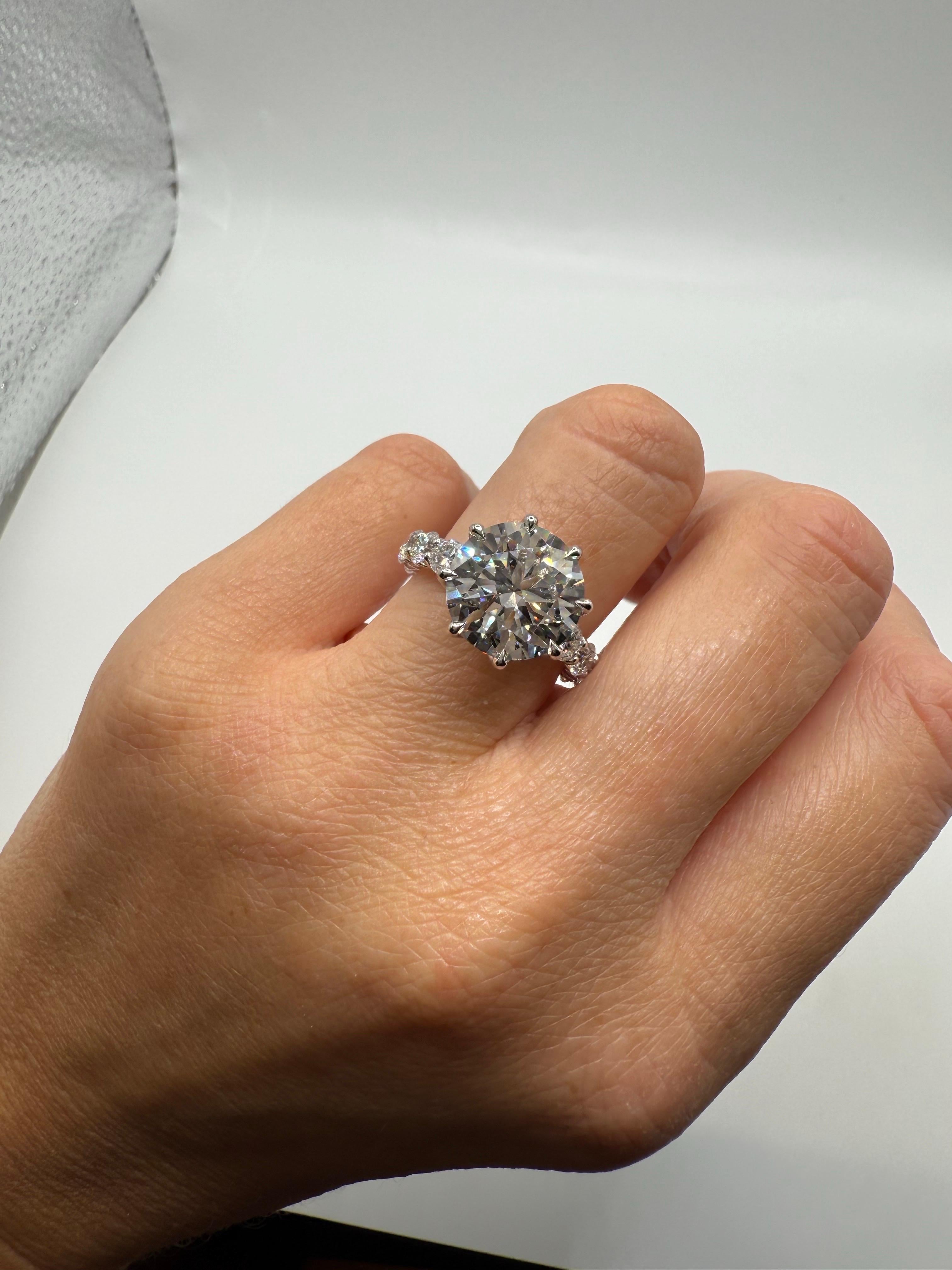 Diamant central de 5 carats certifié par la GIA, de pureté SI1 et de couleur F, accompagné de 3 carats de diamants plus petits sur la bande. Cette bague est luxueusement florale et très confortable au doigt. Le design tulipe maintient la bague en