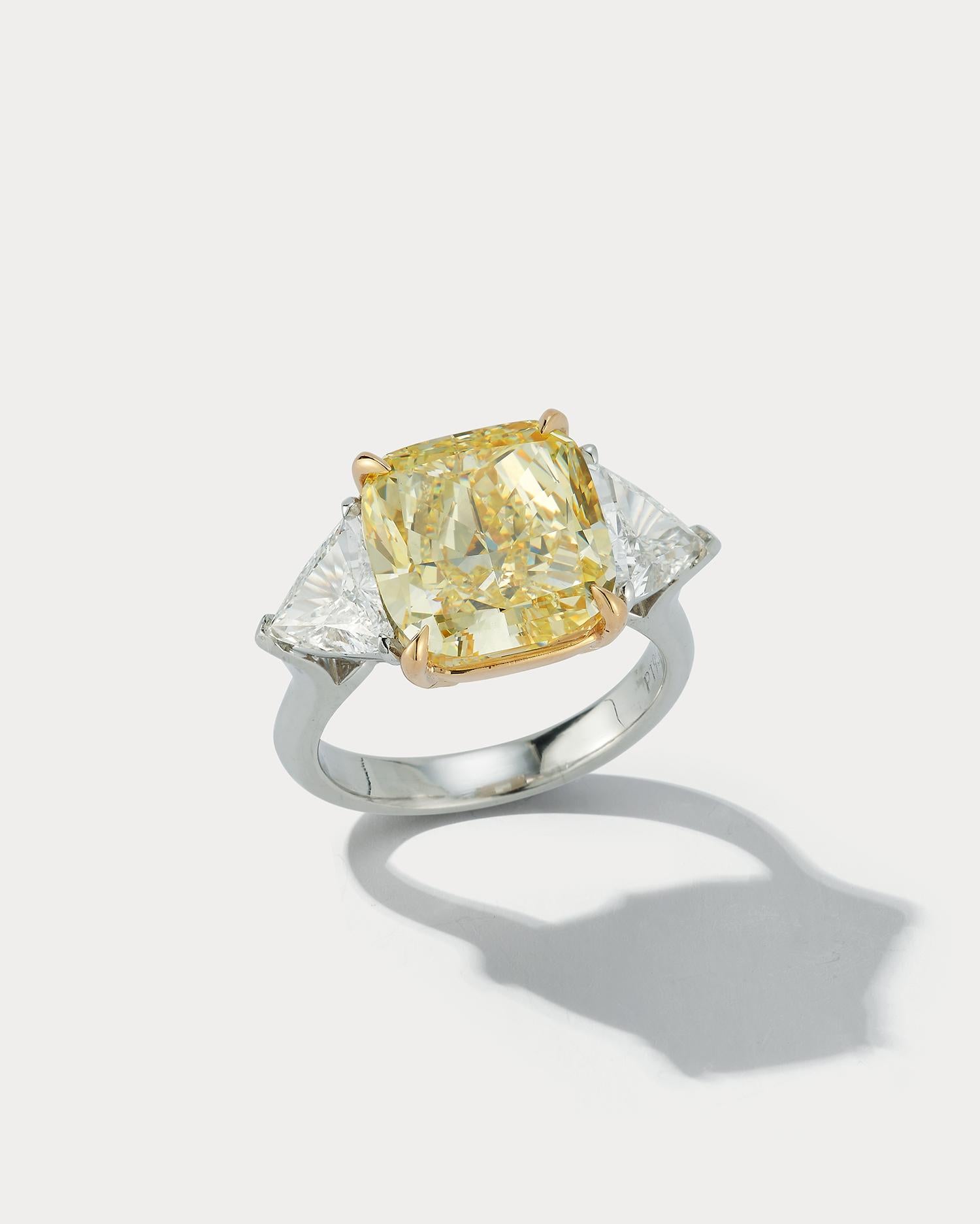 Une bague étonnante pour tous les jours. Au centre, un diamant de 8,01 carats de couleur jaune fantaisie, VS1, taille coussin, certifié par la GIA. Il est flanqué de deux grands Trillions pesant au total 1,45 carats. La pierre centrale est sertie en