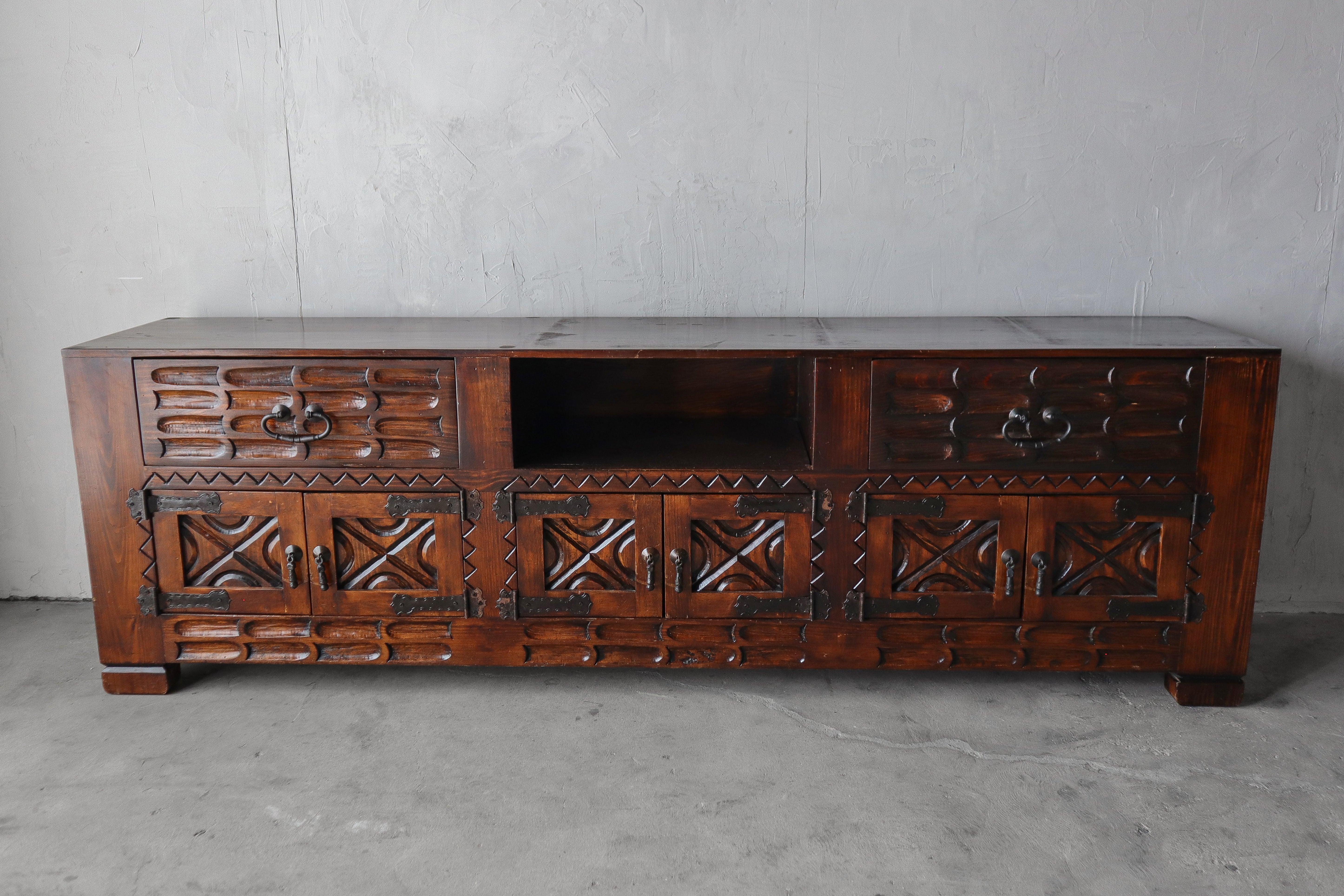 This substantial custom cabinet was handmade in Mexico by the original owner.  It measures 8ft in length making it a real statement piece of furniture.  It has the most beautiful handcarved details that add visual interest.  It can be used as a