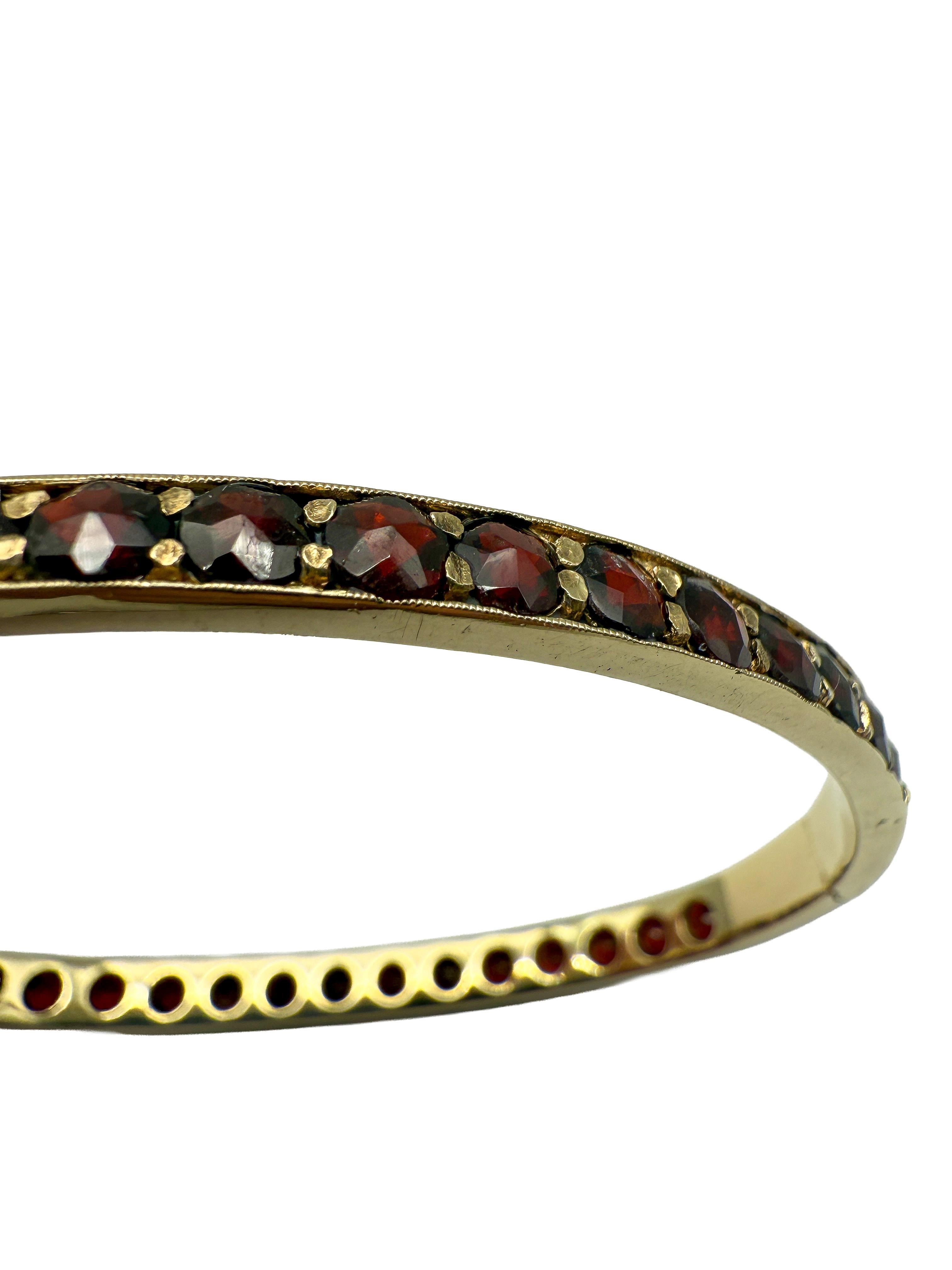 Este brazalete de elegancia clásica elaborado en oro amarillo de 8 quilates cautiva con su expresivo diseño y el cálido resplandor de los granates naturales. Con 36 gemas finamente engastadas en un tono rojo intenso y un peso total en quilates de