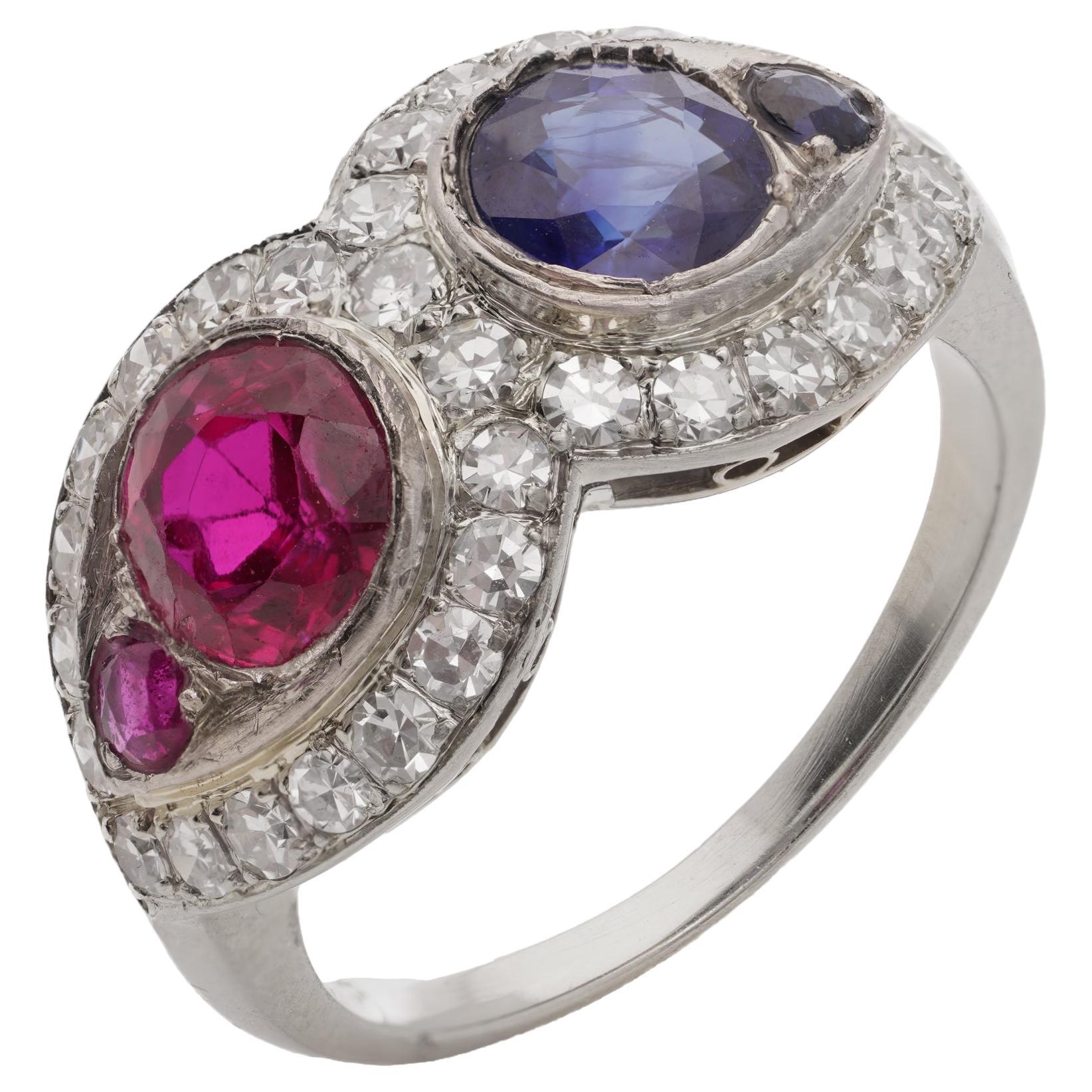 18kt. white gold ruby and sapphire ring, surrounded by round brilliant diamonds For Sale