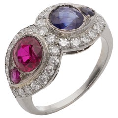 18kt. white gold ruby and sapphire ring, surrounded by round brilliant diamonds