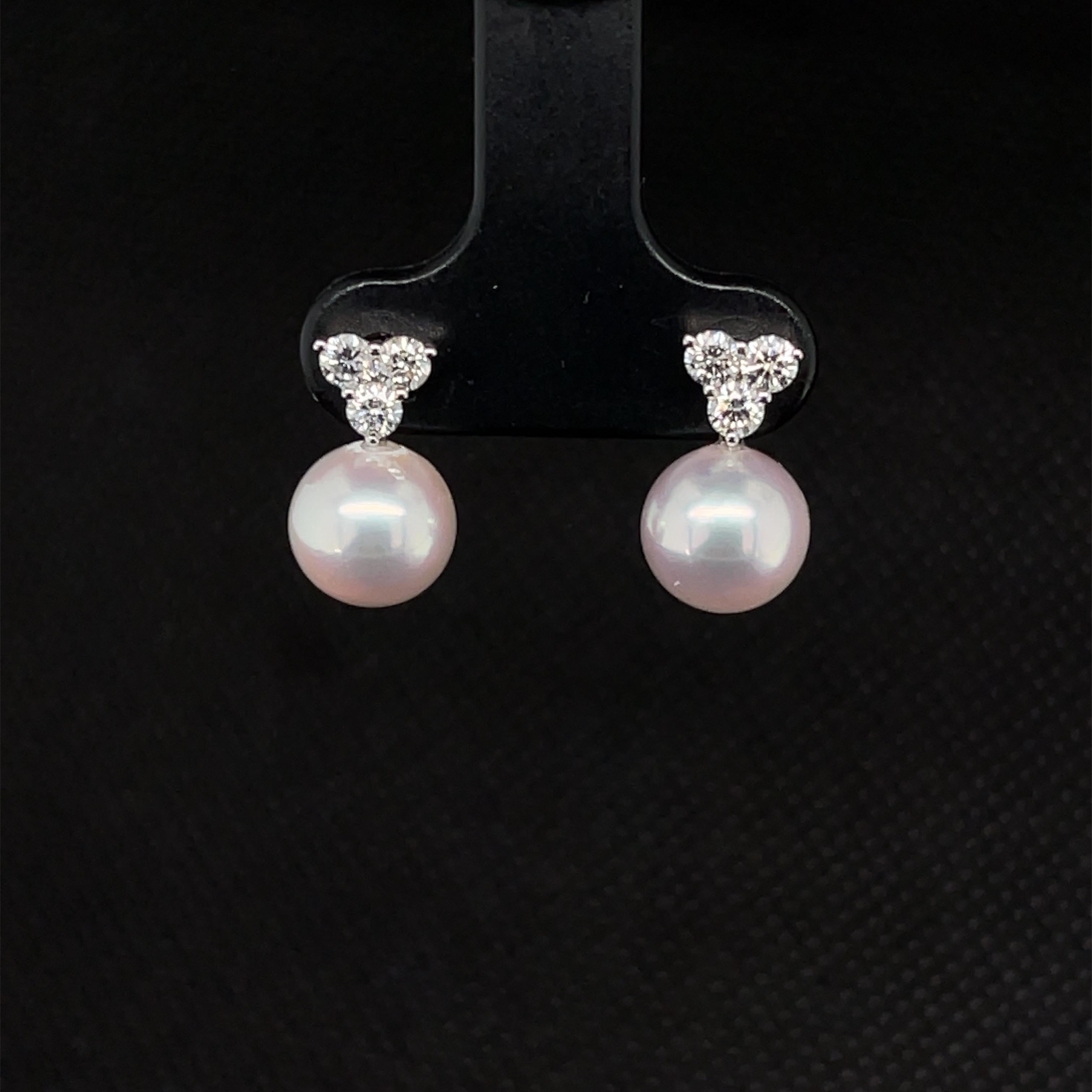 These gorgeous pearl and diamond stud earrings feature a beautifully matched pair of 8.00 mm Akoya saltwater pearls set in 18k white gold. Three round brilliant cut diamonds have been arranged in an inverted triangular and set above each pearl for