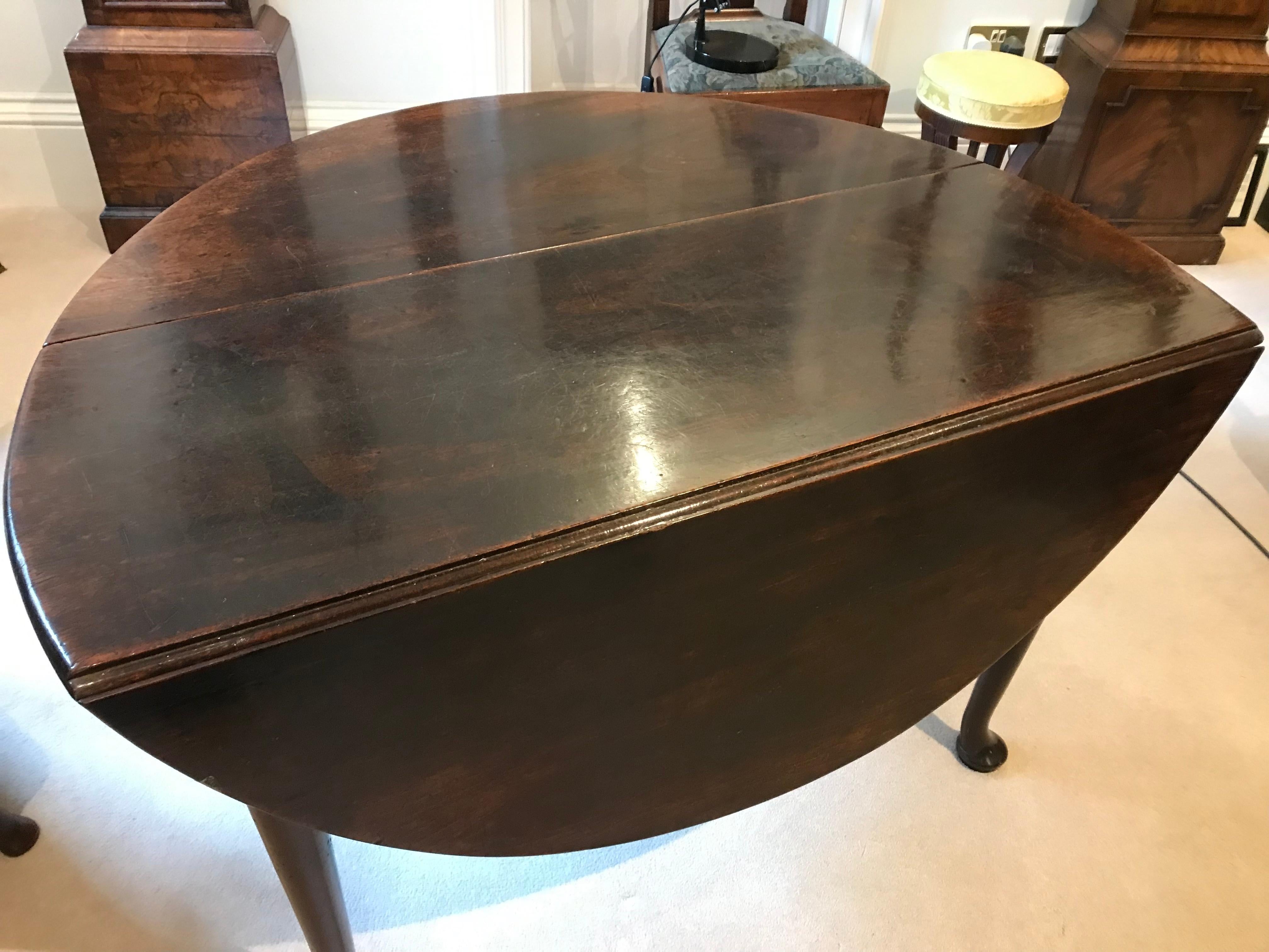 Mid 18th century solid mahogany drop leaf table with four tapering legs and pad feet.