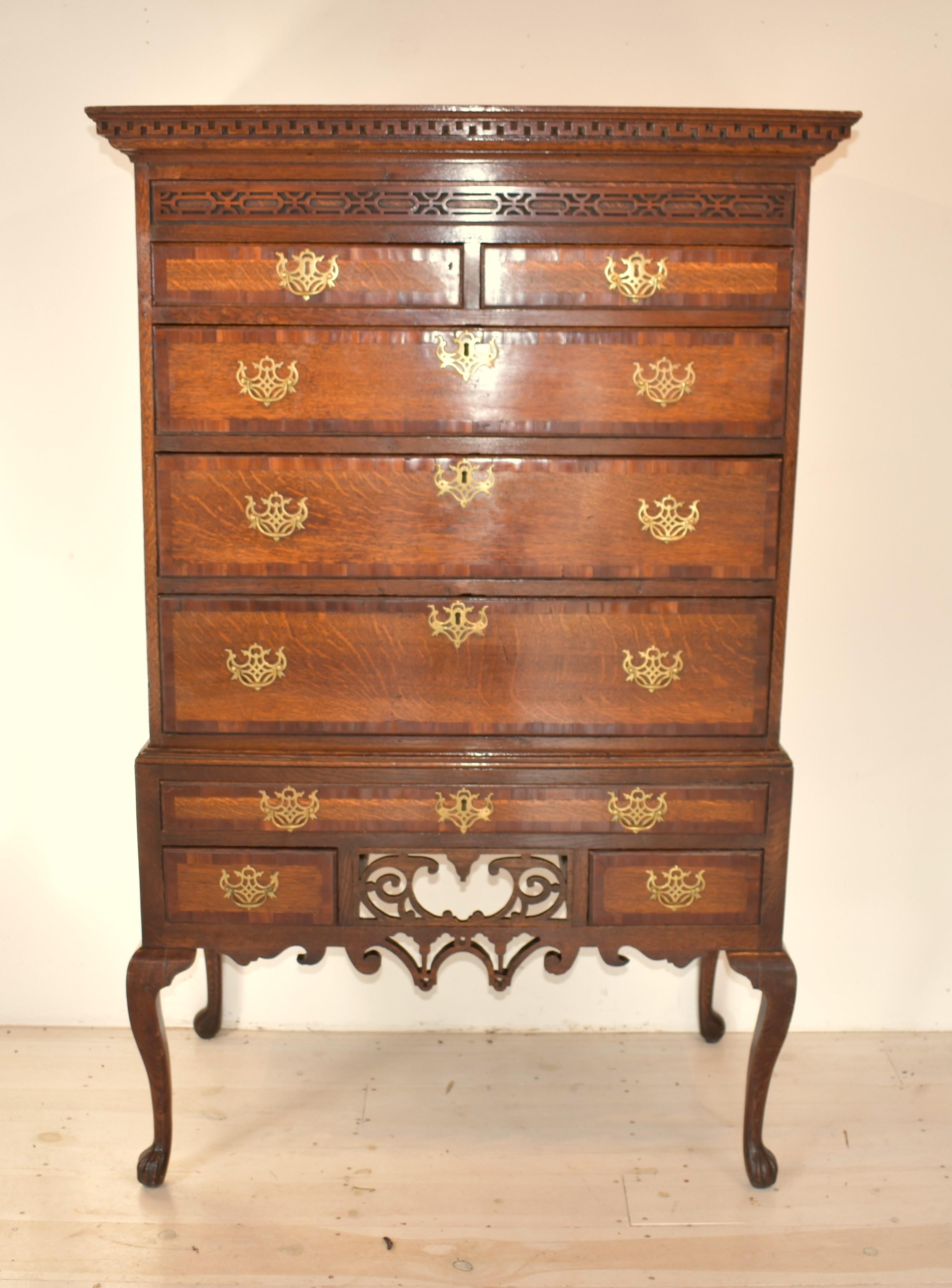  A superb untouched oak and fruitwood crossbanded chest on stand, c. 1740. Although this is a piece of vernacular furniture, the design is elegant and the craftsmanship skilled. The cornice is dentil moulded above with intricate blind fretwork