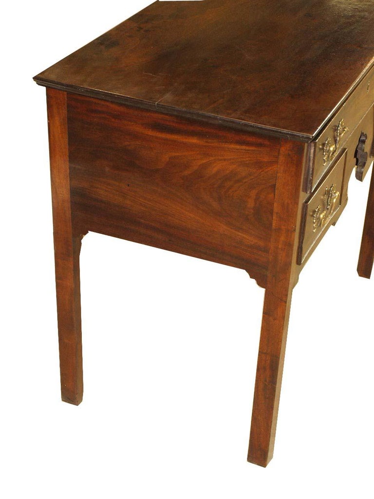 18th century Chippendale lowboy with beautiful figured mahogany top , the cock beaded drawers with original rococo swan neck brass pulls, nicely shaped center apron, the straight legs with chamfer on the interior sides. The top has minor ink stains.