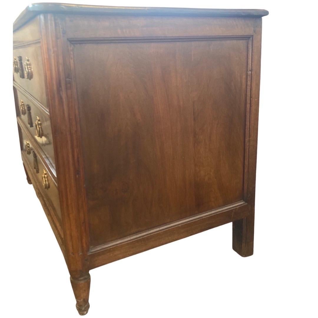 Louis XVI commode hand-made in Italy in the mid 1700s using walnut. This is a wonderful large and low commode that can be perfect for both a bedroom and also an entry way. The commode shows a two-board top with rounded front corners and ogee edges.