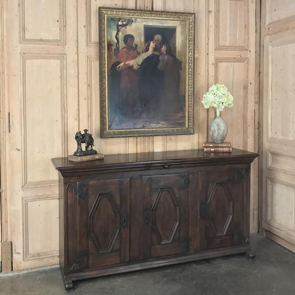 18th century Spanish buffet features a rugged, rustic appearance, a result of the efforts of talented rural artisans who used tools much as their ancestors used hundreds of years prior. A flattened diamond pattern appears on the cabinet doors, hung