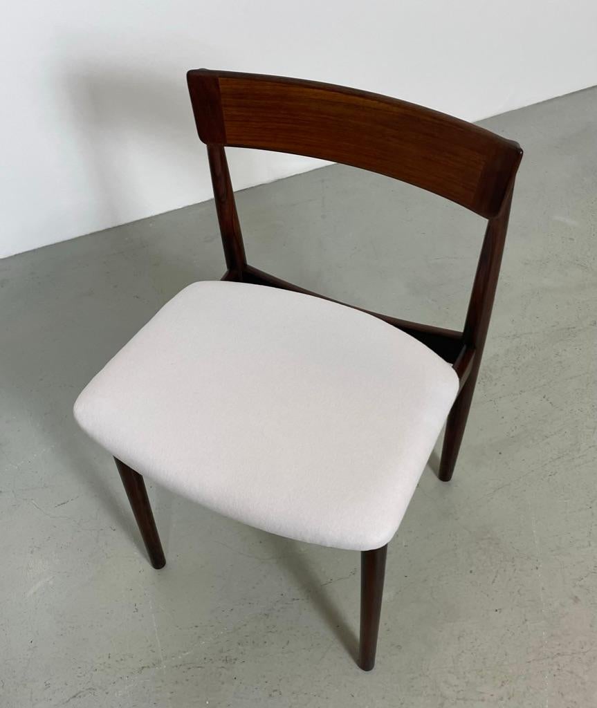 This rare set of 8 chairs was design by Henry Rosengren Hansen for Brande Møbelindustri. Made in Denmark during the 1960s. The dining chairs are made of solid rosewood. A signature and stamp under each chair attest to its authenticity. 

The seat