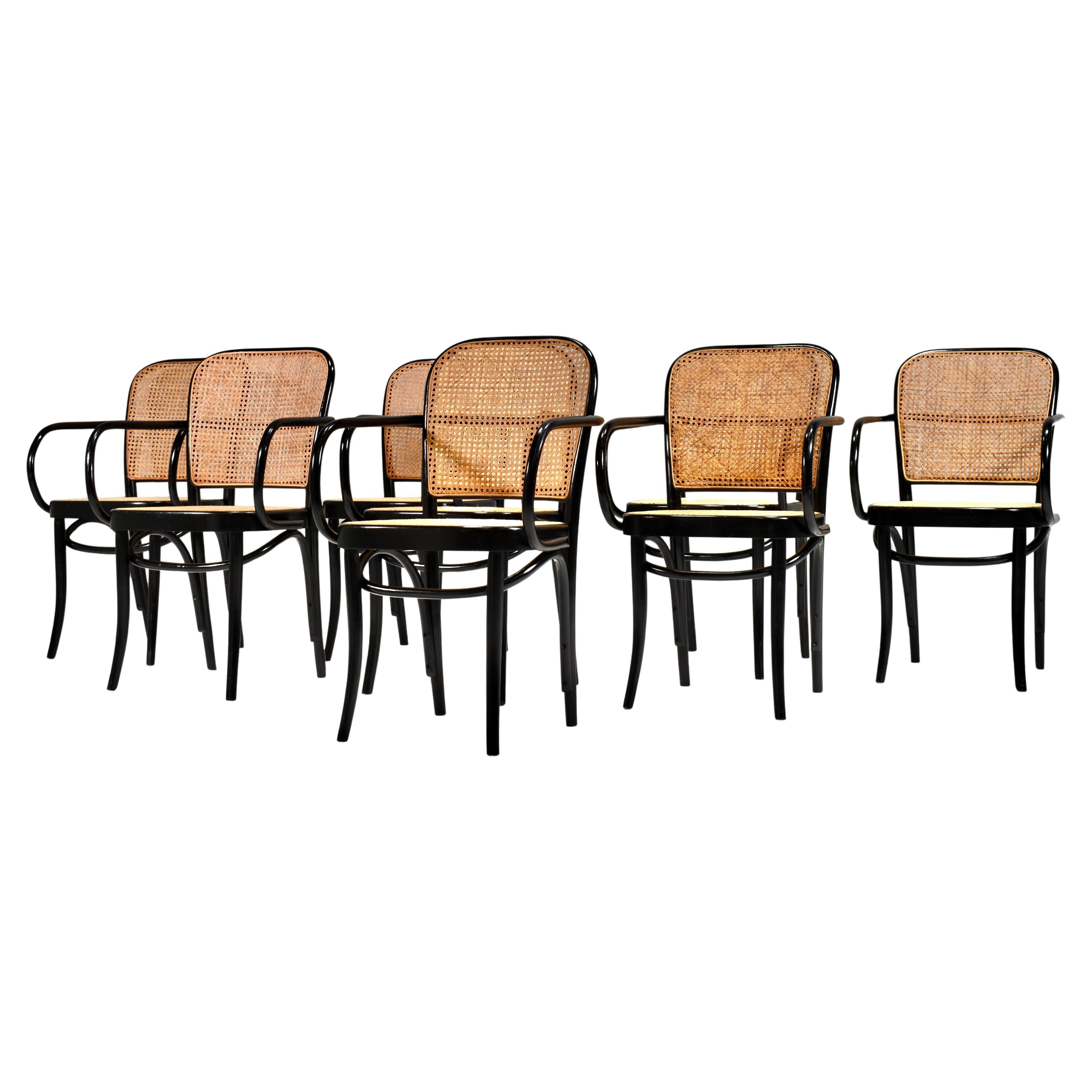 1 chair is a slightly later model and somewhat different from the other 7 (see images).

Designer: Josef Hoffmann
Manufacturer: Thonet
Country: Austria
Model: Thonet 811 'Prague / Praga' dining armchairs
Color: Black
Material: Bent beechwood /