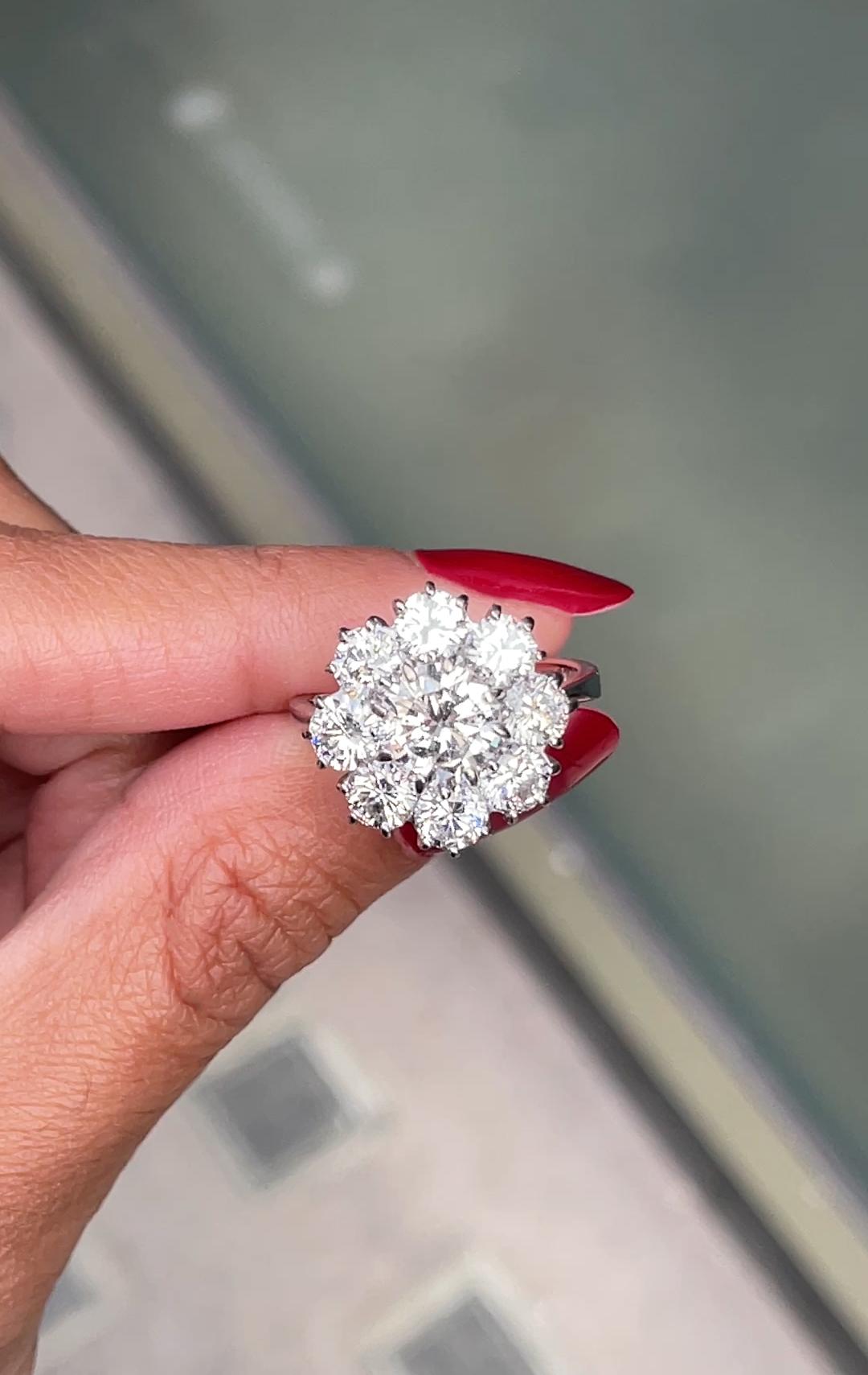 This absolutely stunning 8x1 diamond cluster ring is set with a 1.53 carat round brilliant cut diamond mounted in an 8 claw, open back setting. Surrounding the centrepiece diamond are a constellation of diamonds, forming a cluster that accentuates